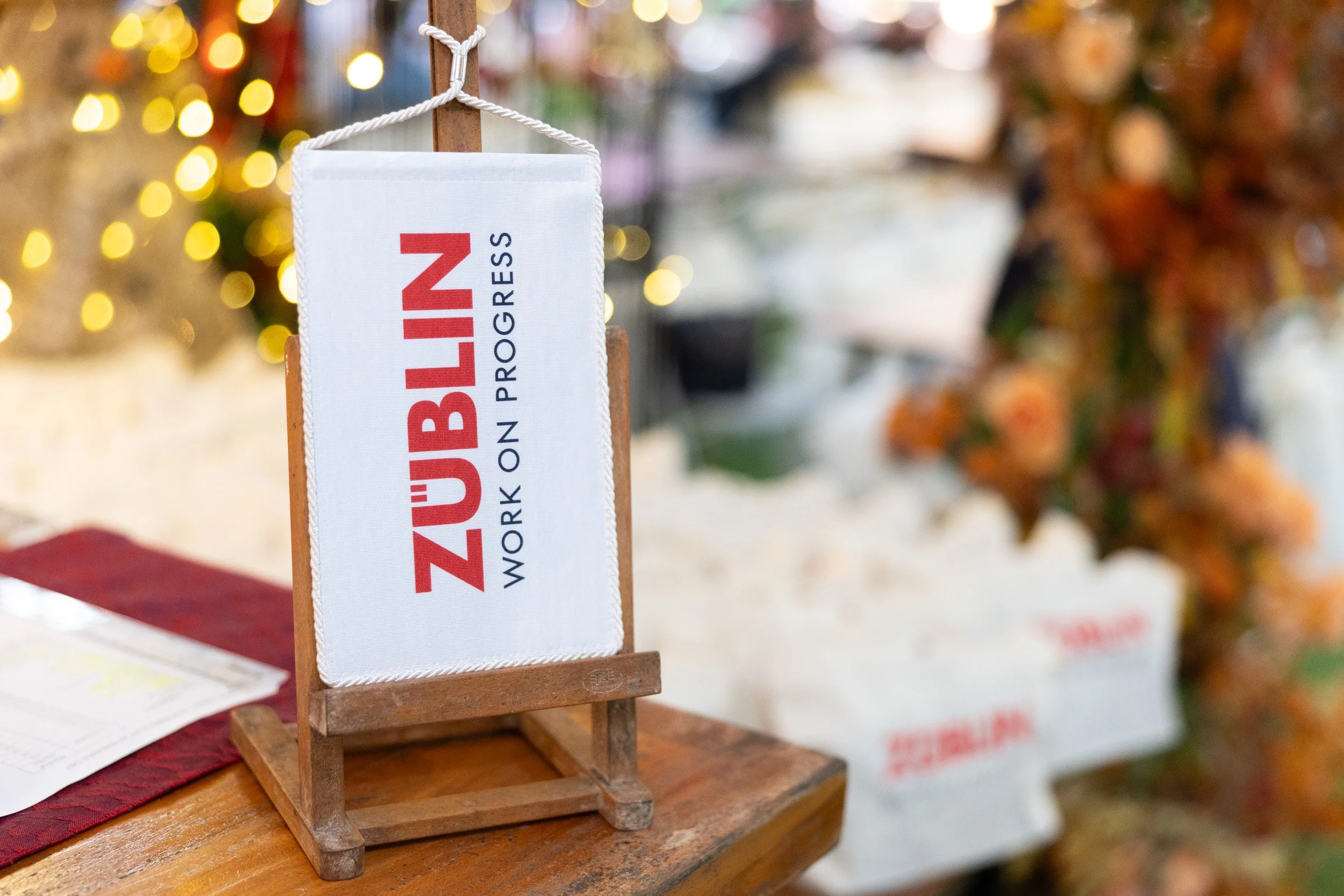  Close-up detail of branded Züblin signage positioned on the event reception check-in desk. 