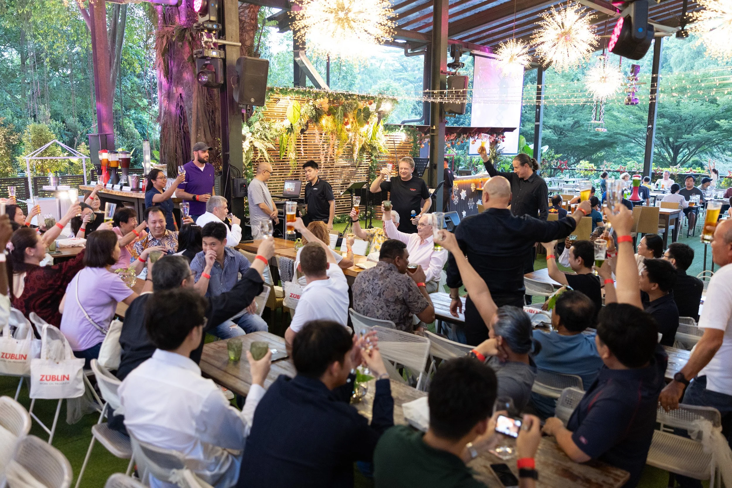  Wide angle event photograph of Züblin employees cheering during Managing Director Josef Kofler's address. 