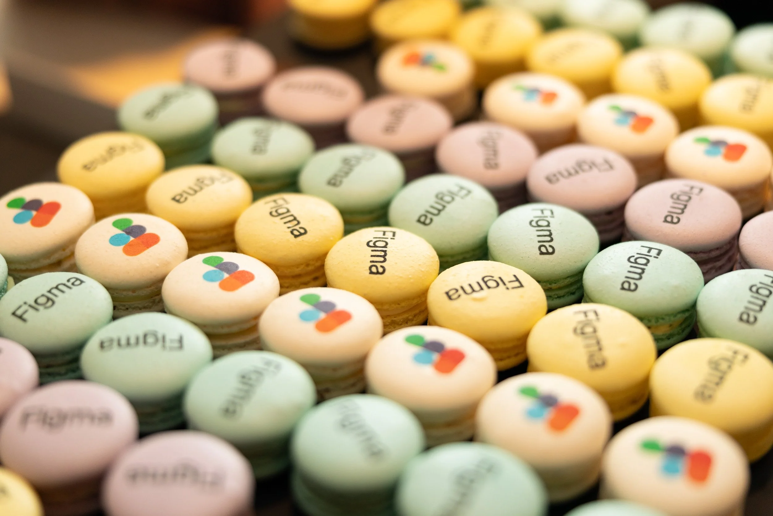  Close-up detail of custom French macarons printed with the Figma corporate logo. 