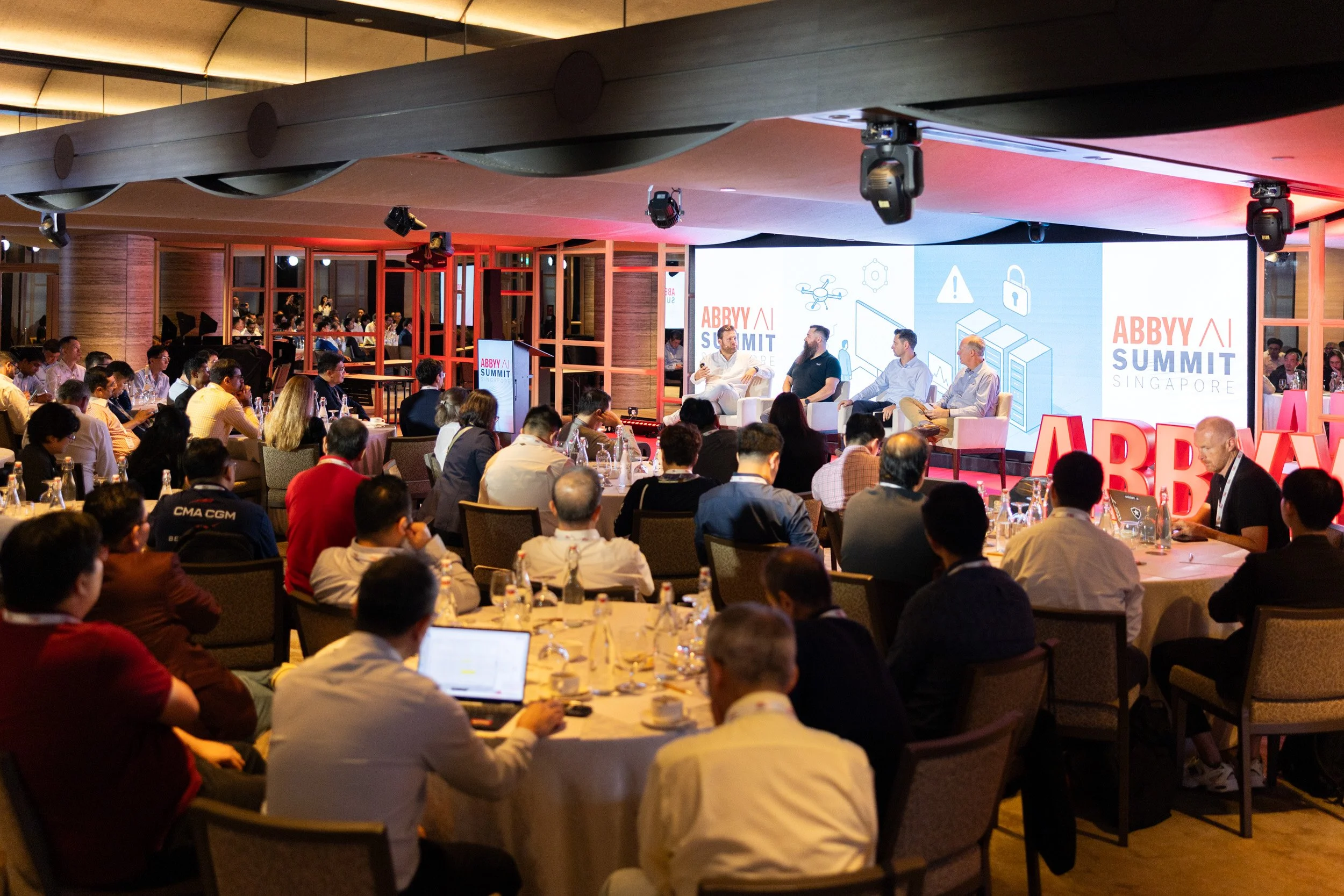  Executive panel discussion featuring Alexander Hanff, Loic Villerot, Jon Knisley, and Maxime Vermeir on stage. 