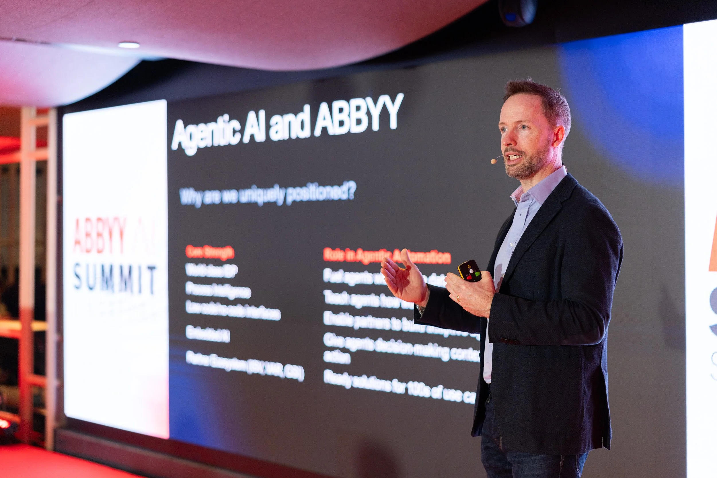  Close-up photograph of keynote speaker Neil Murphy delivering an address on stage at the ABBYY AI Summit. 