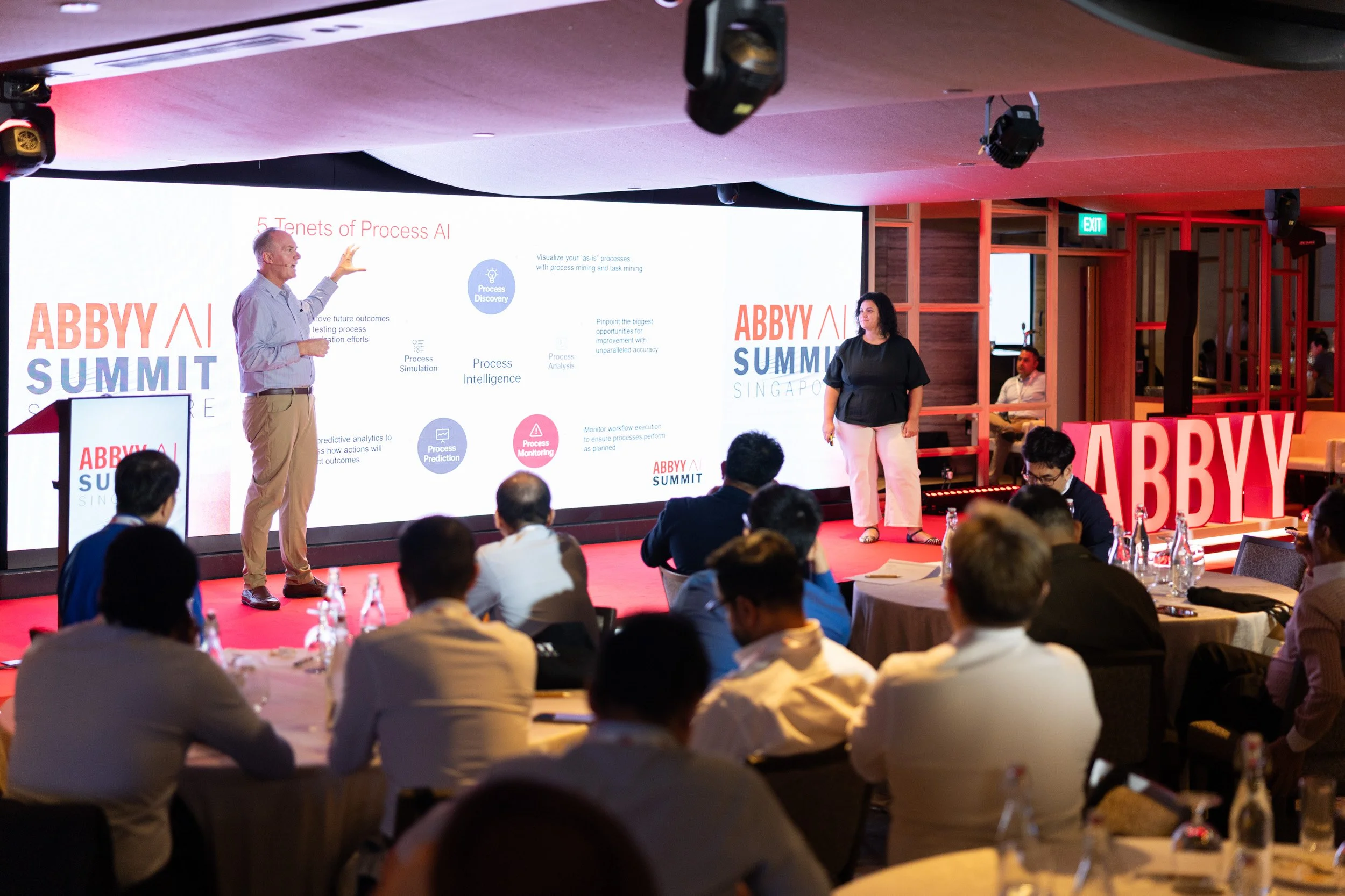 Medium shot of Slavena Hristova and Jon Knisley co-leading a presentation at the ABBYY AI Summit Singapore. 