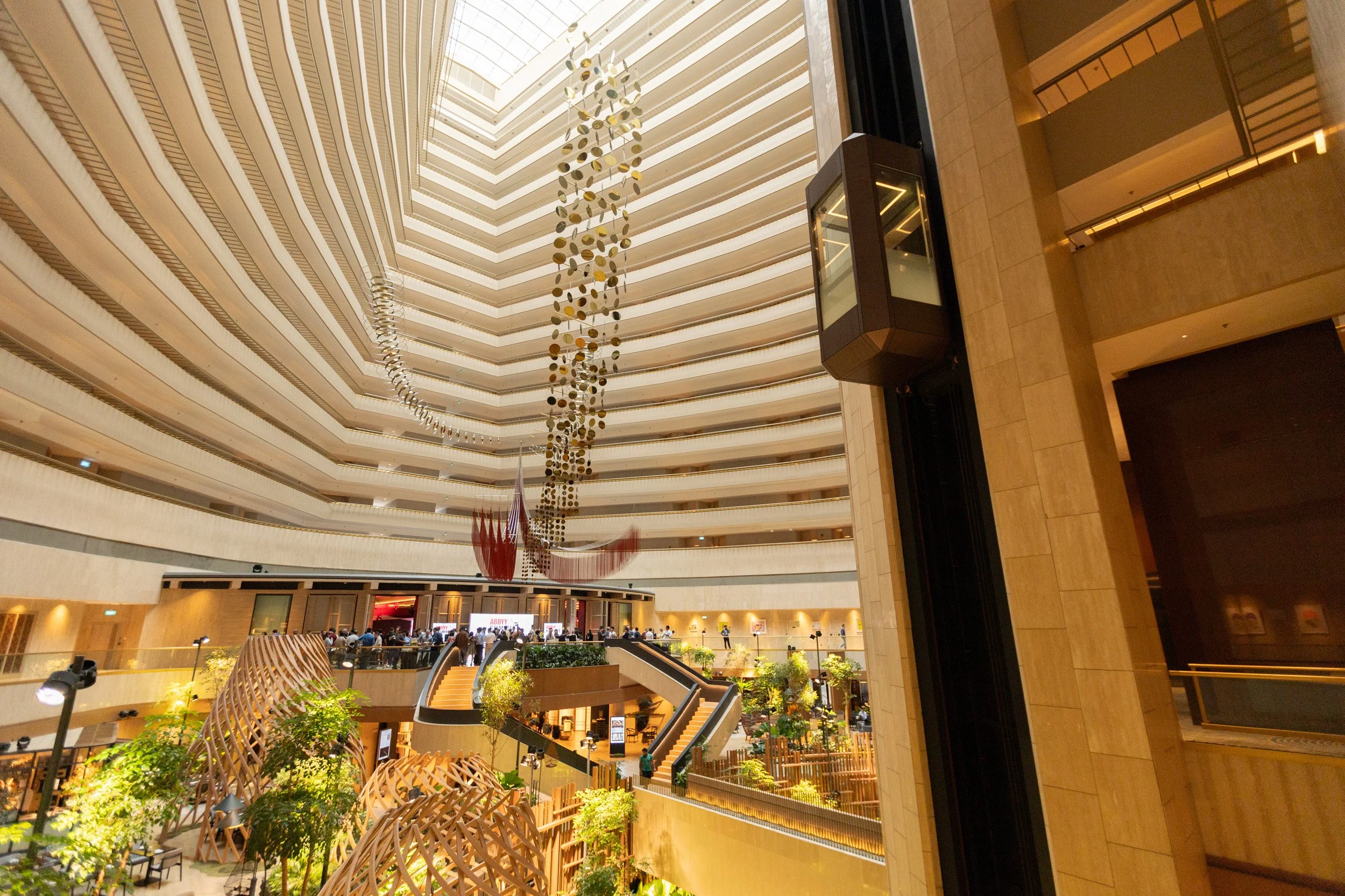  Ultra-wide architectural photo showcasing the soaring atrium interior of PARKROYAL COLLECTION Marina Bay outside the event space. 