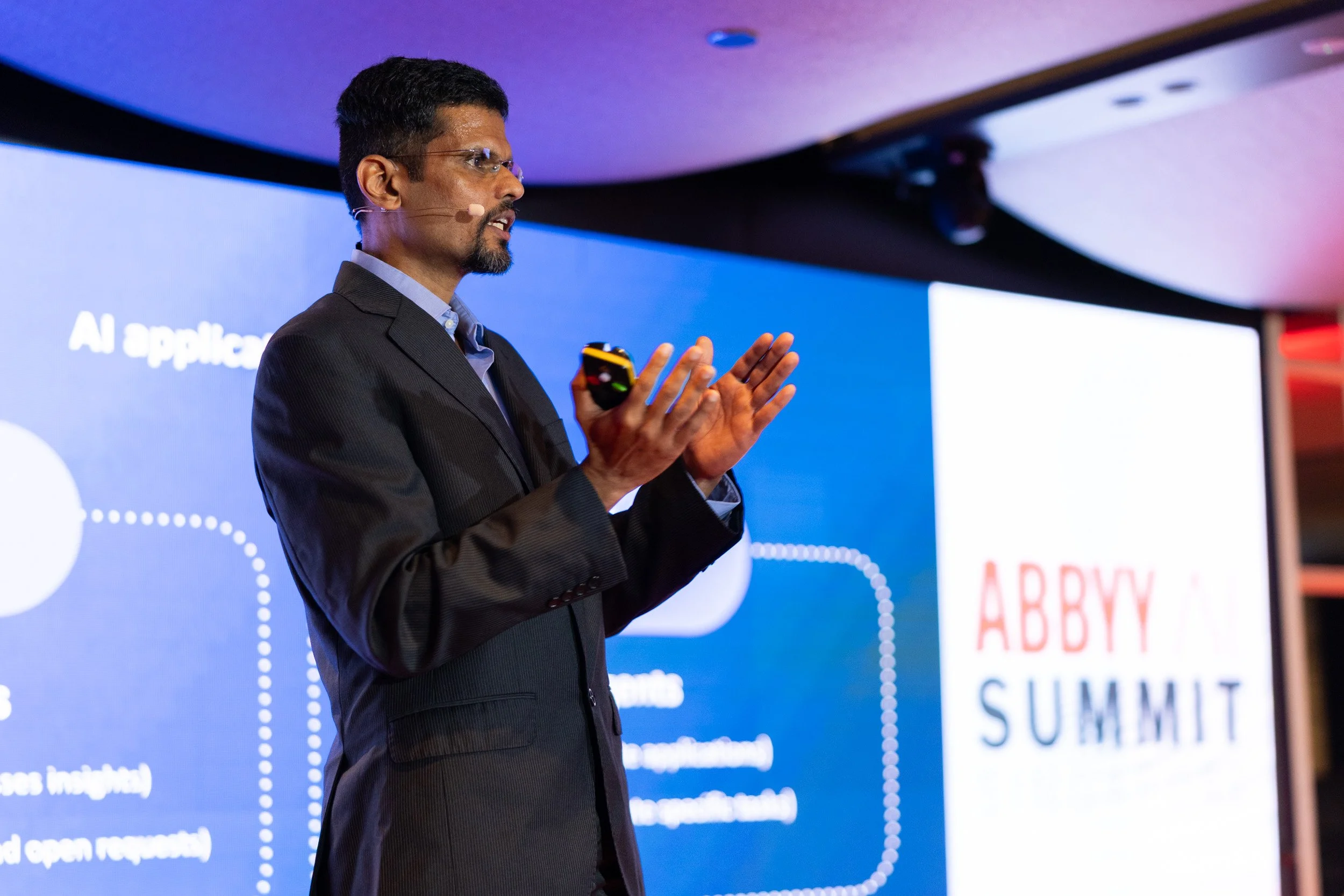  Close-up portrait of speaker Manoj Bhat presenting on stage during the ABBYY AI Summit. 