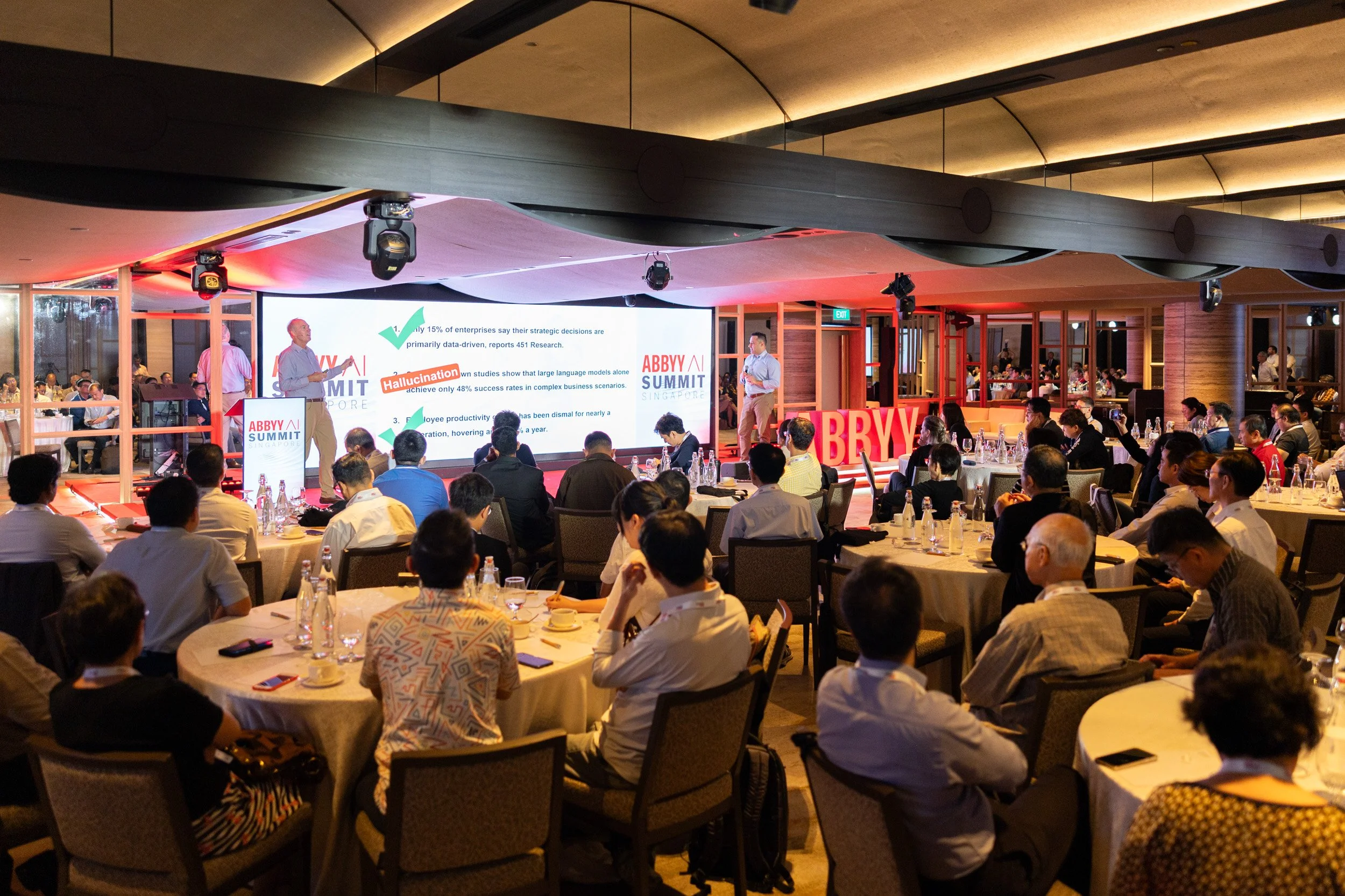  Wide angle stage presentation photo of Jon Knisley speaking at the AI Summit Singapore. 