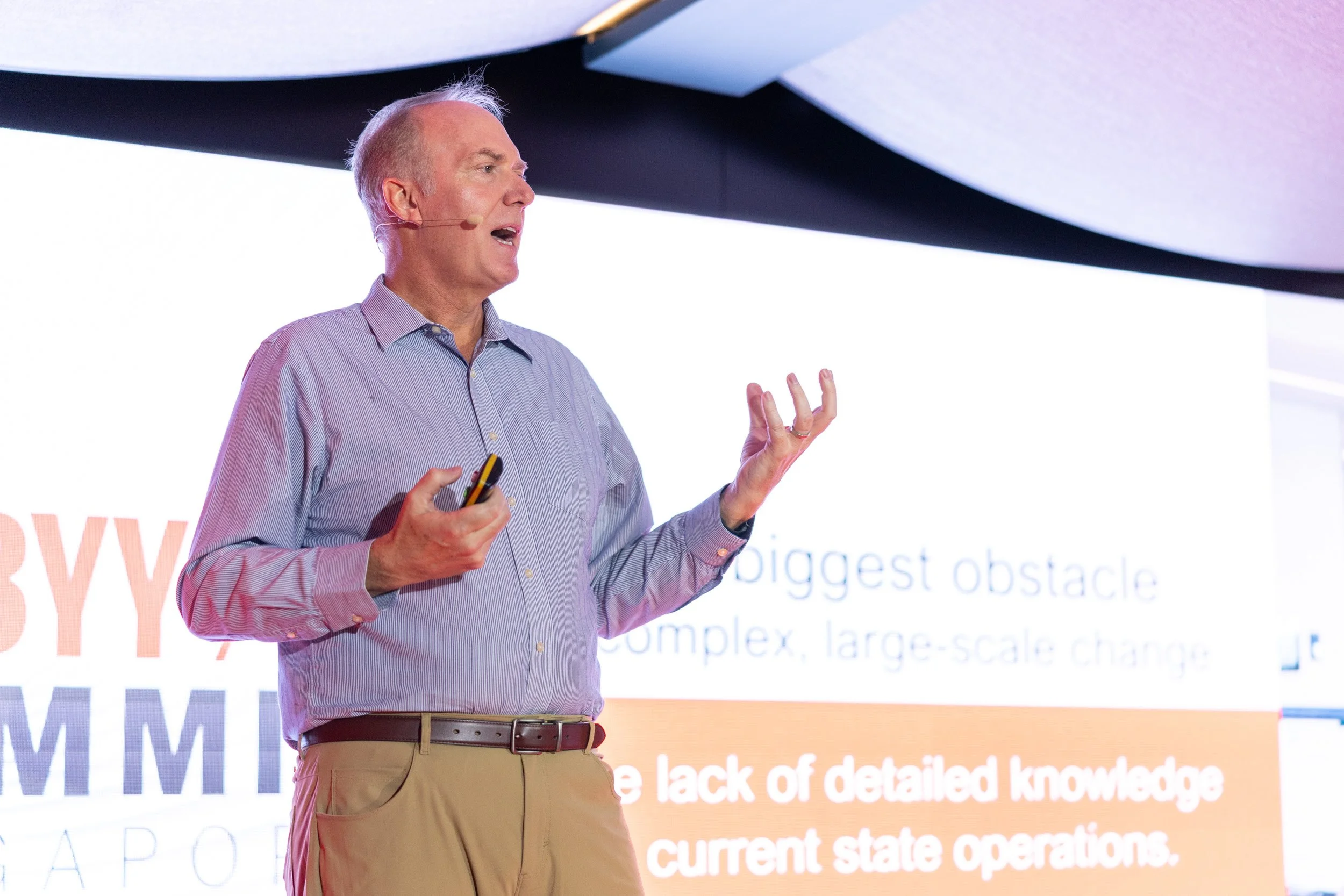  Close-up photograph of Jon Knisley presenting AI workflows on stage. 
