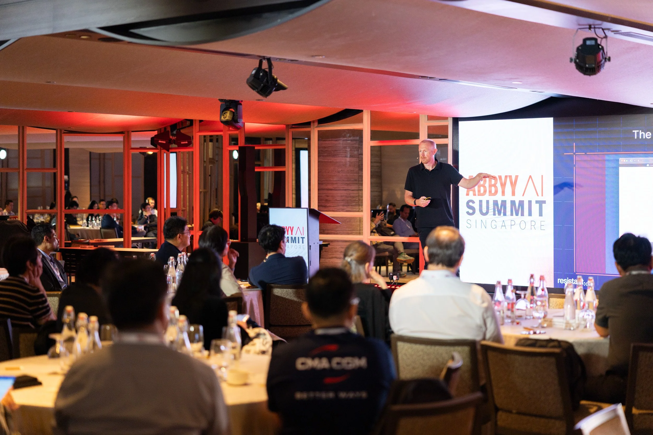  Medium shot of Jan Syrinek presenting on stage during the ABBYY AI Summit. 
