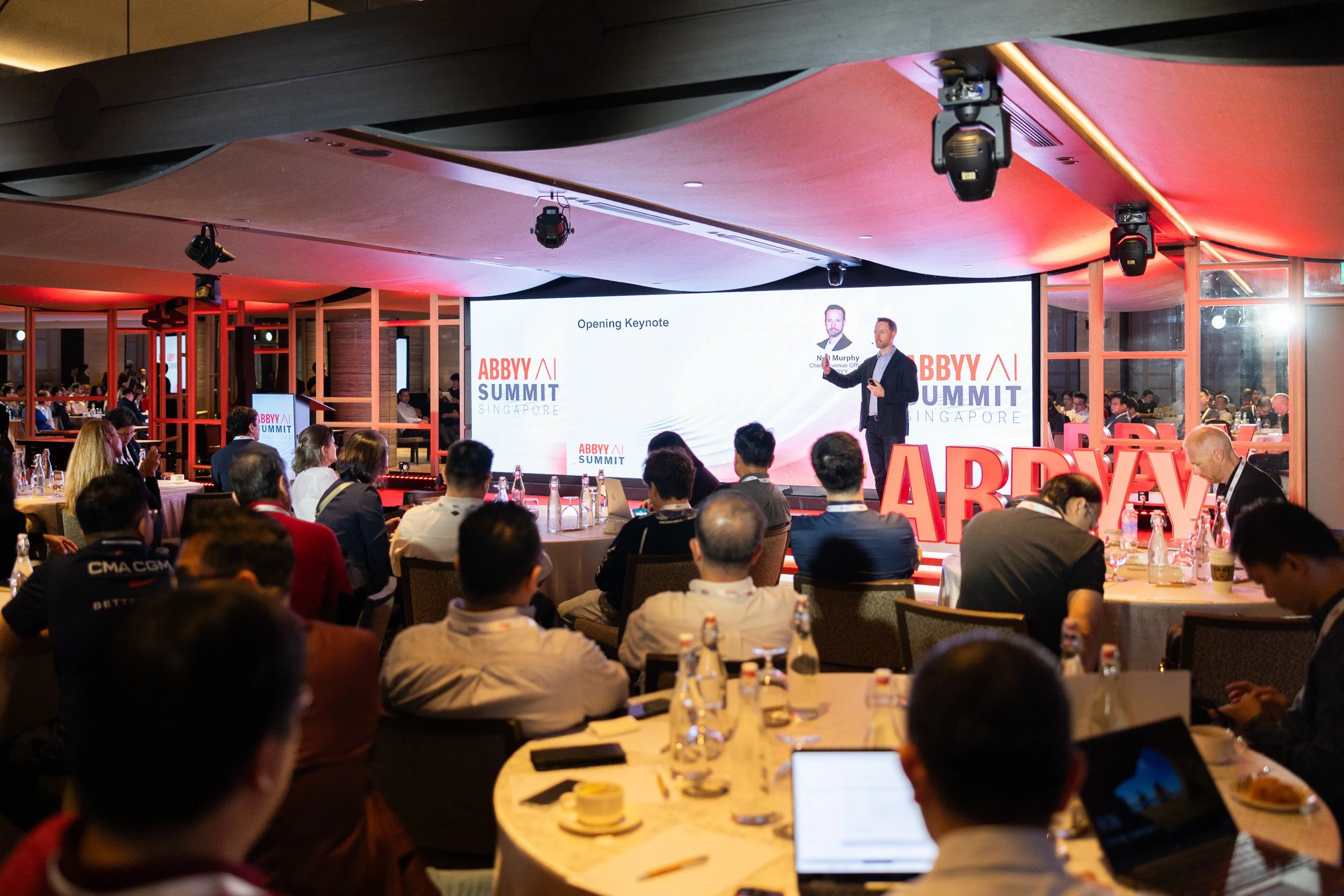  Wide angle stage photo of Neil Murphy addressing delegates at the ABBYY AI Summit Singapore. 