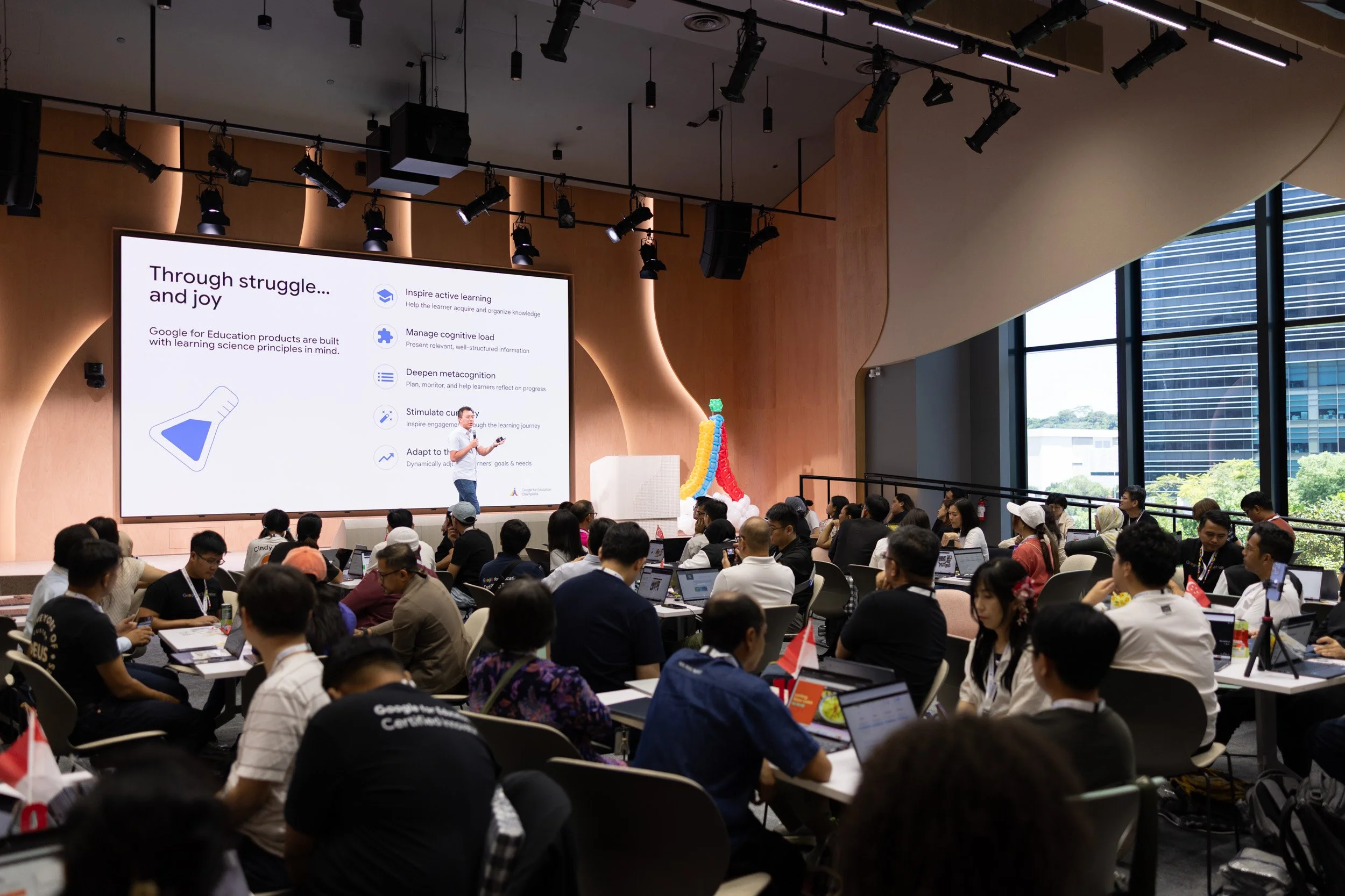  Wide presentation shot of Suan Yeo addressing the audience in the Singapore Symposium room. 