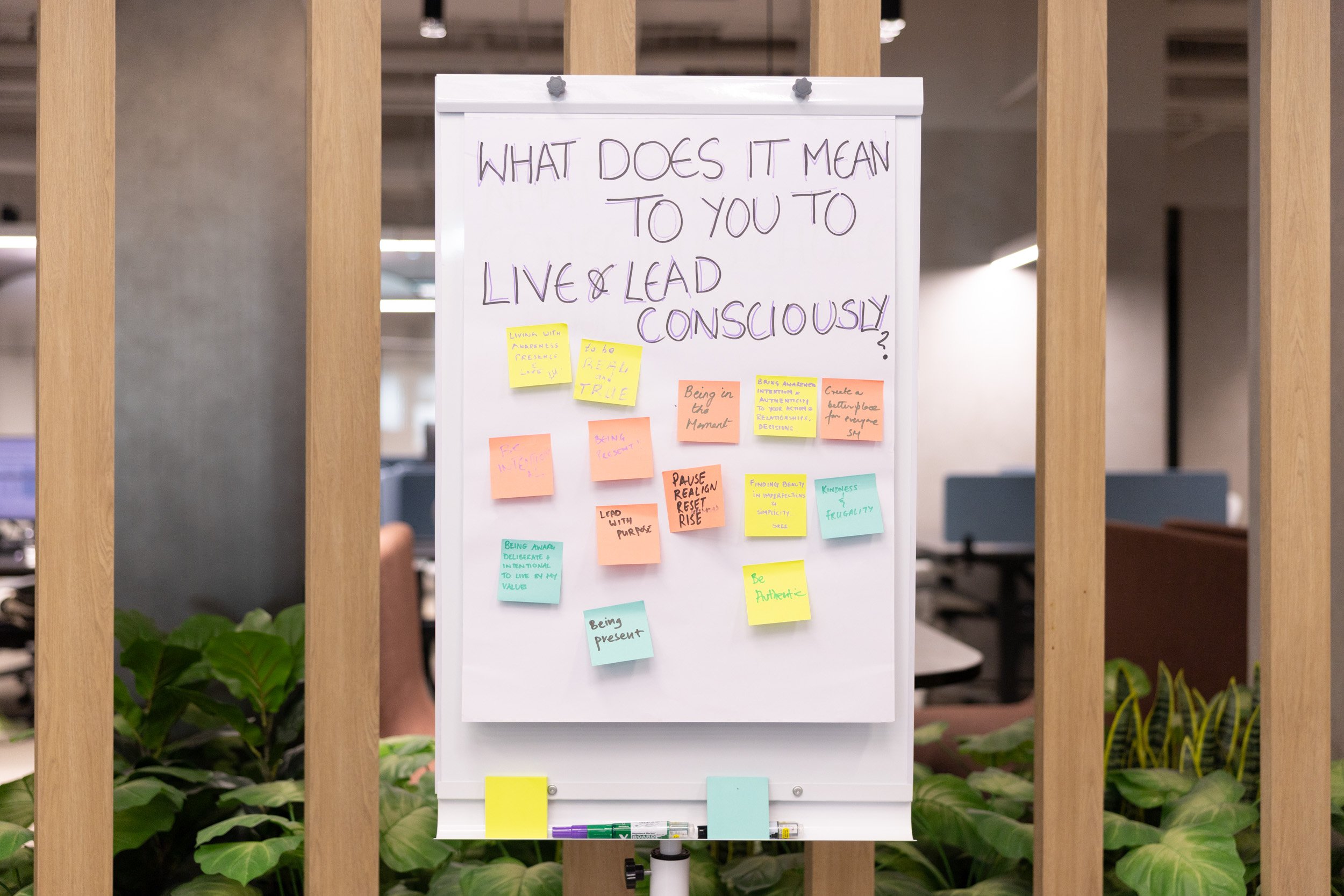  Interactive attendee message board displaying handwritten notes on living and leading consciously. 