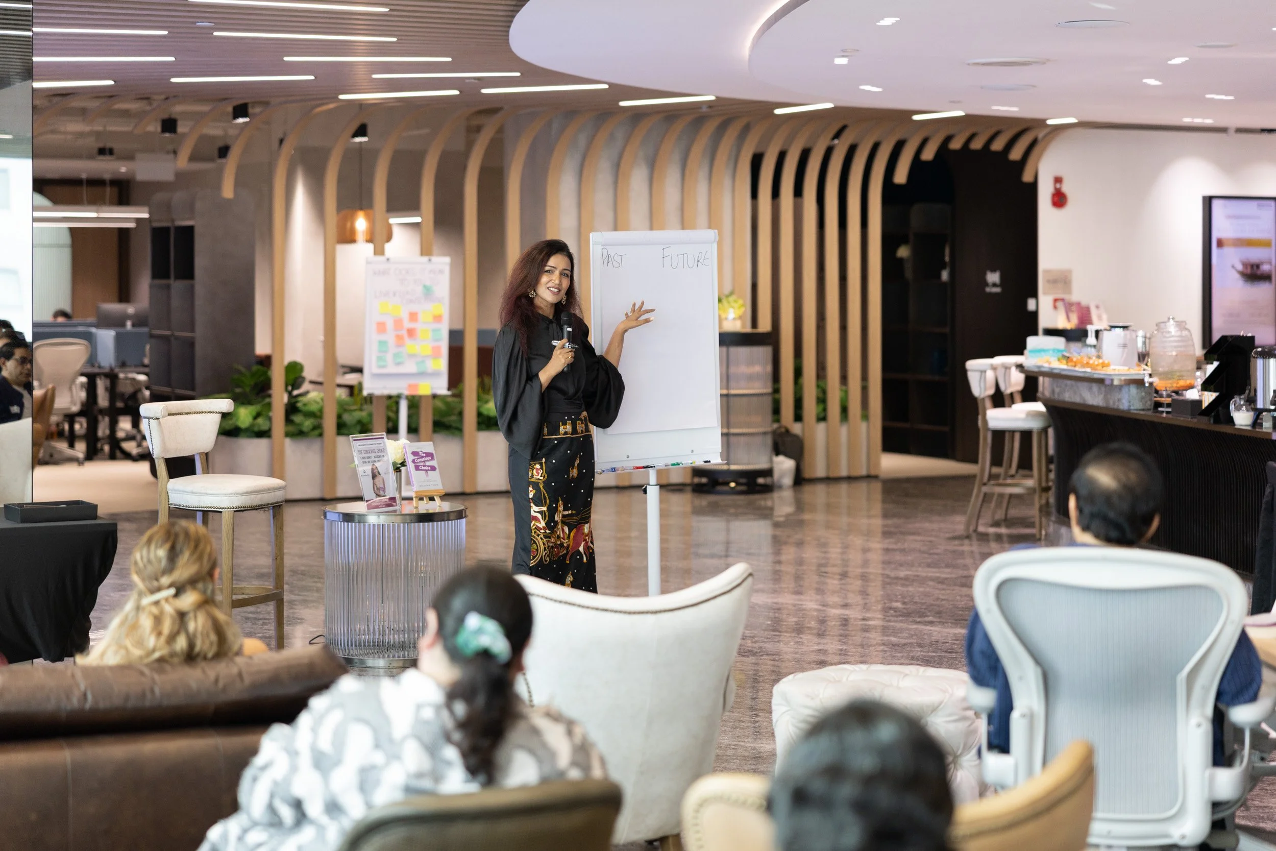 Medium shot of Bhavna Toor referencing the interactive presentation board during her talk. 