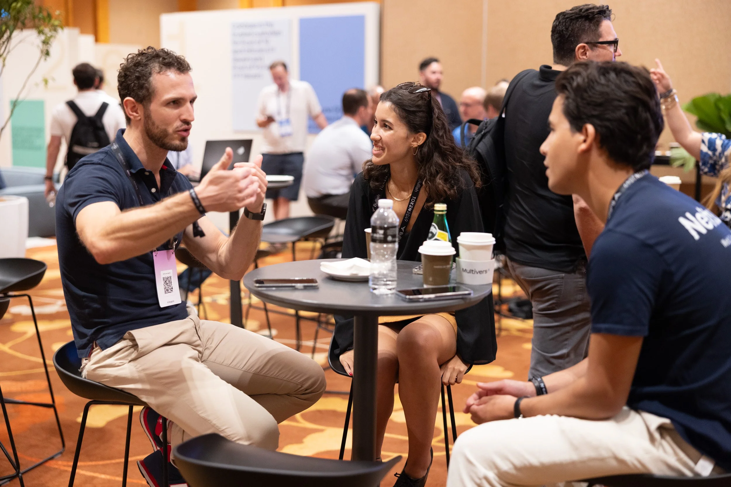  Executive networking candid photo showing delegates conversing during a Token 2049 conference break. 