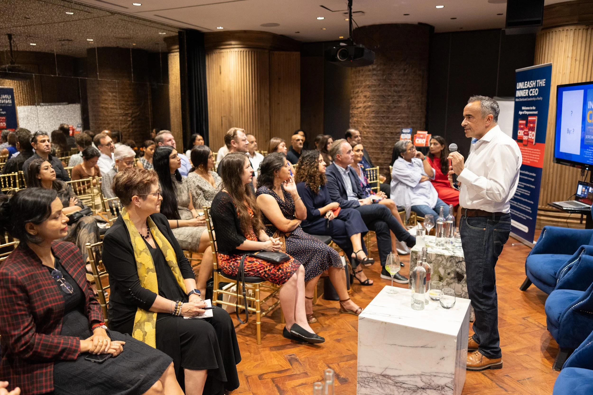 Wide stage view of Jeremy Blain speaking to guests during the Unleash the Inner CEO book launch. 