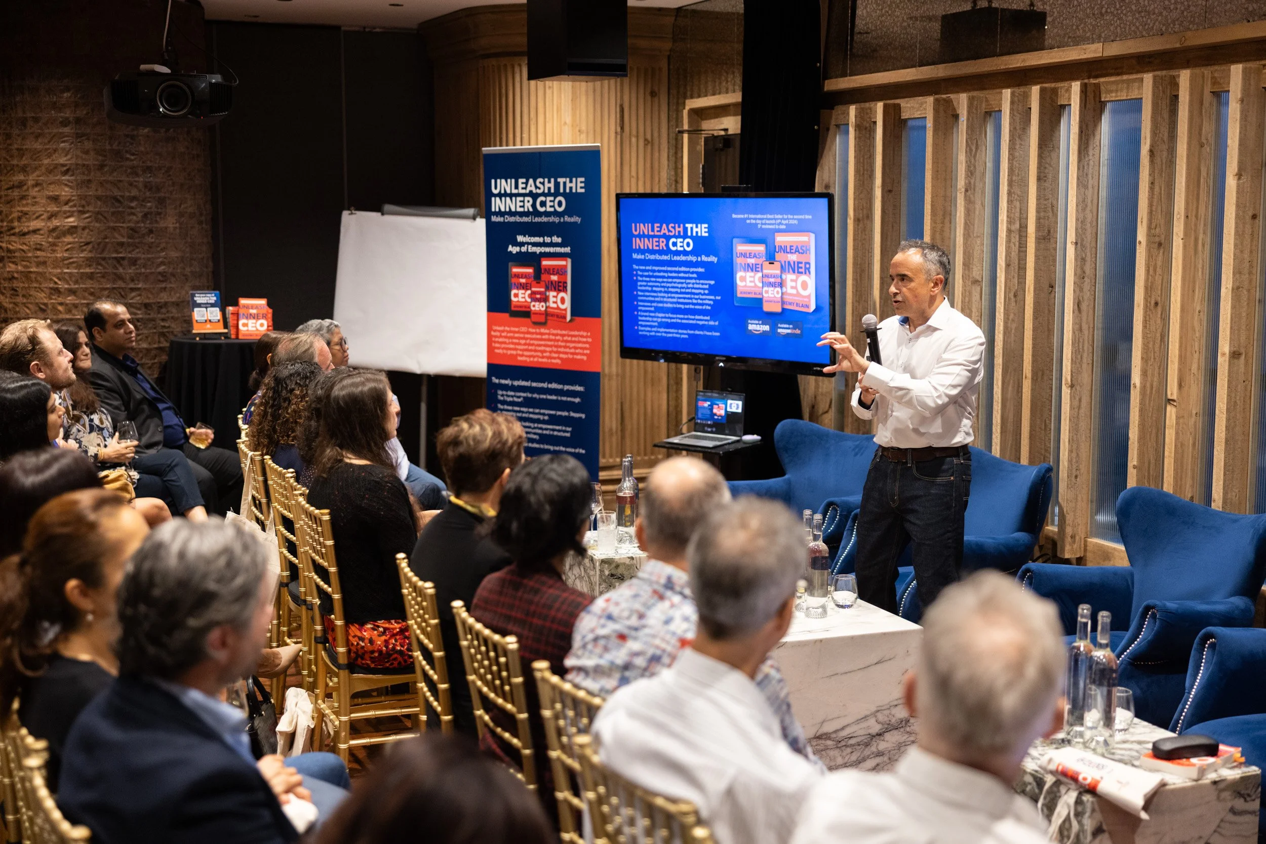  Medium shot of Jeremy Blain sharing insights on executive leadership with the audience. 