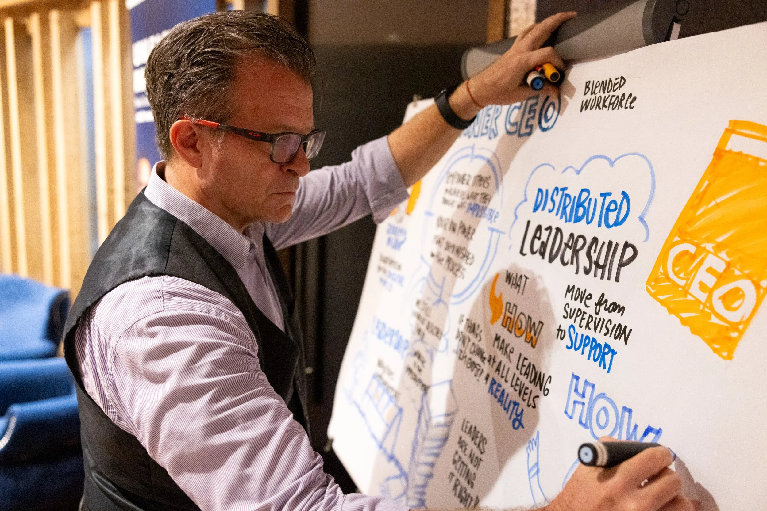  Close-up of the live graphic recording artist creating real-time visual summary artwork during the talk. 