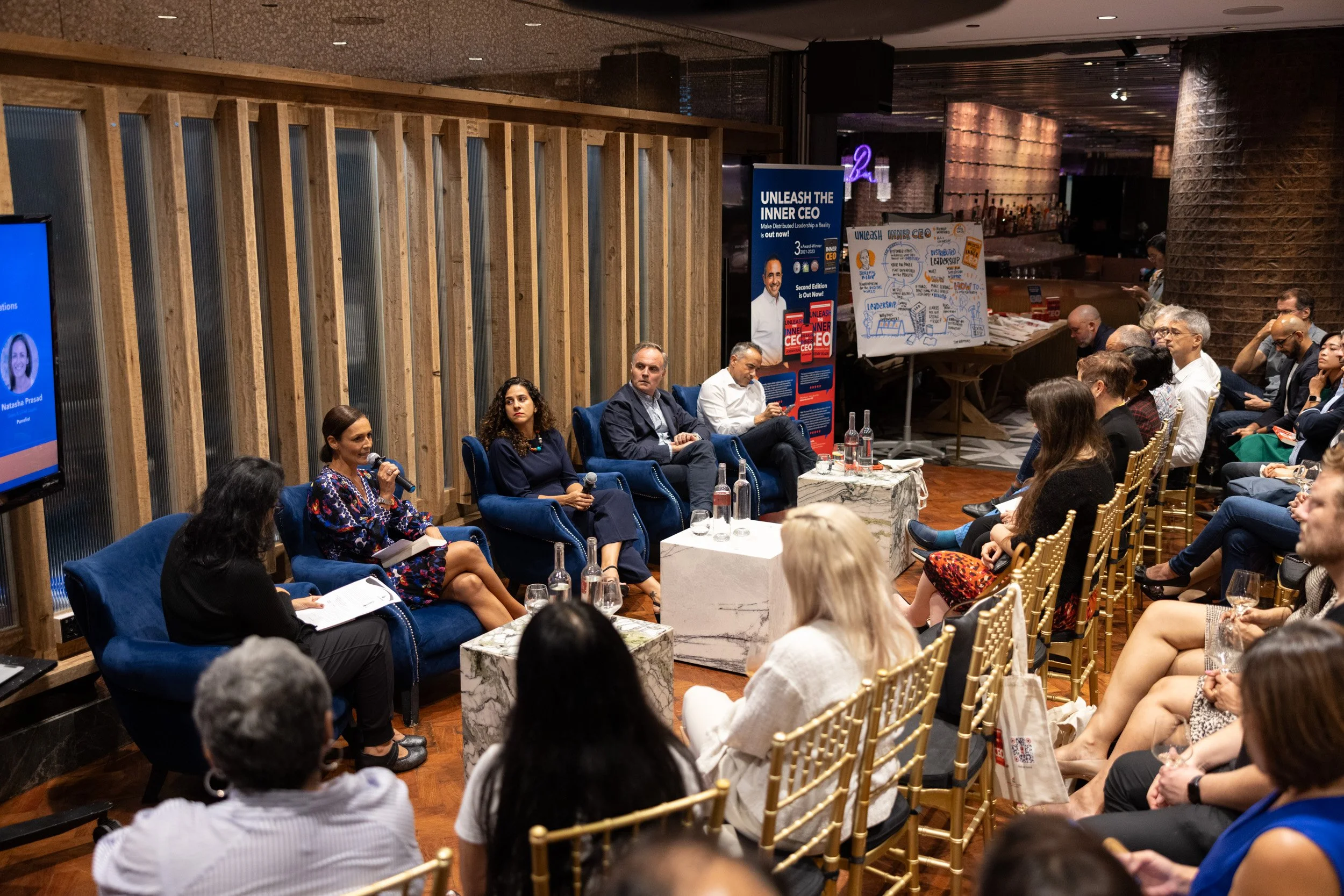  Wide perspective of the panel discussion featuring Jeremy Blain, Bruna Fontes, Antonio Codinach, Natasha Prasad, and moderator Neha Thakkar. 