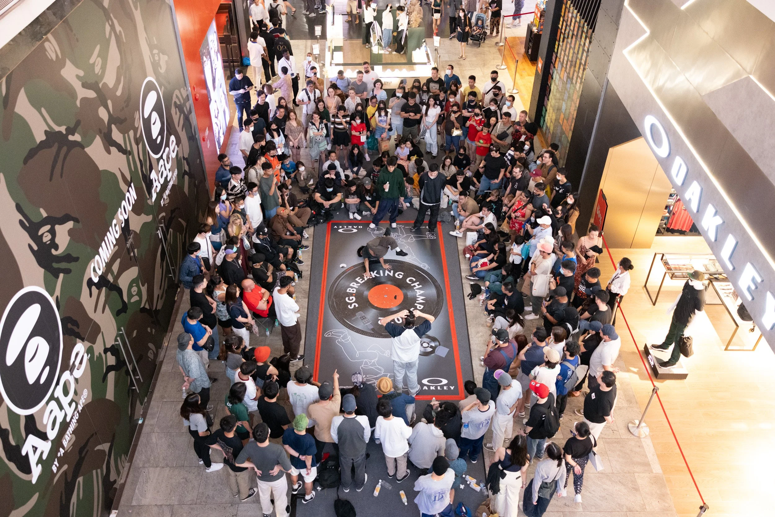  Upper-deck angle shot of a B-boy executing a chair freeze pose on the competition mat. 