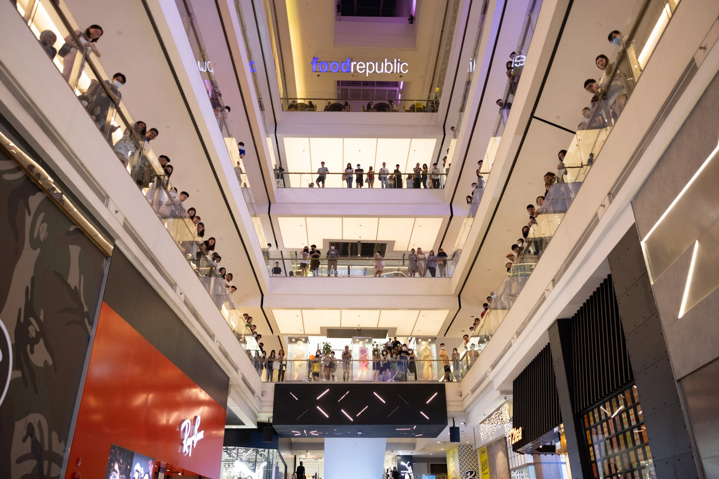  Ground-floor perspective looking up at spectating crowds lined along five atrium balcony levels at 313@somerset. 