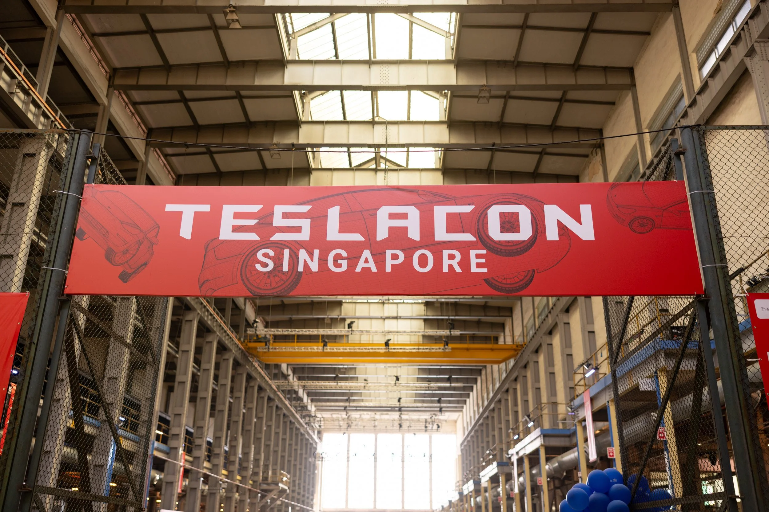  Suspended TeslaCon Singapore event display banner hanging above the main convention hall atrium. 