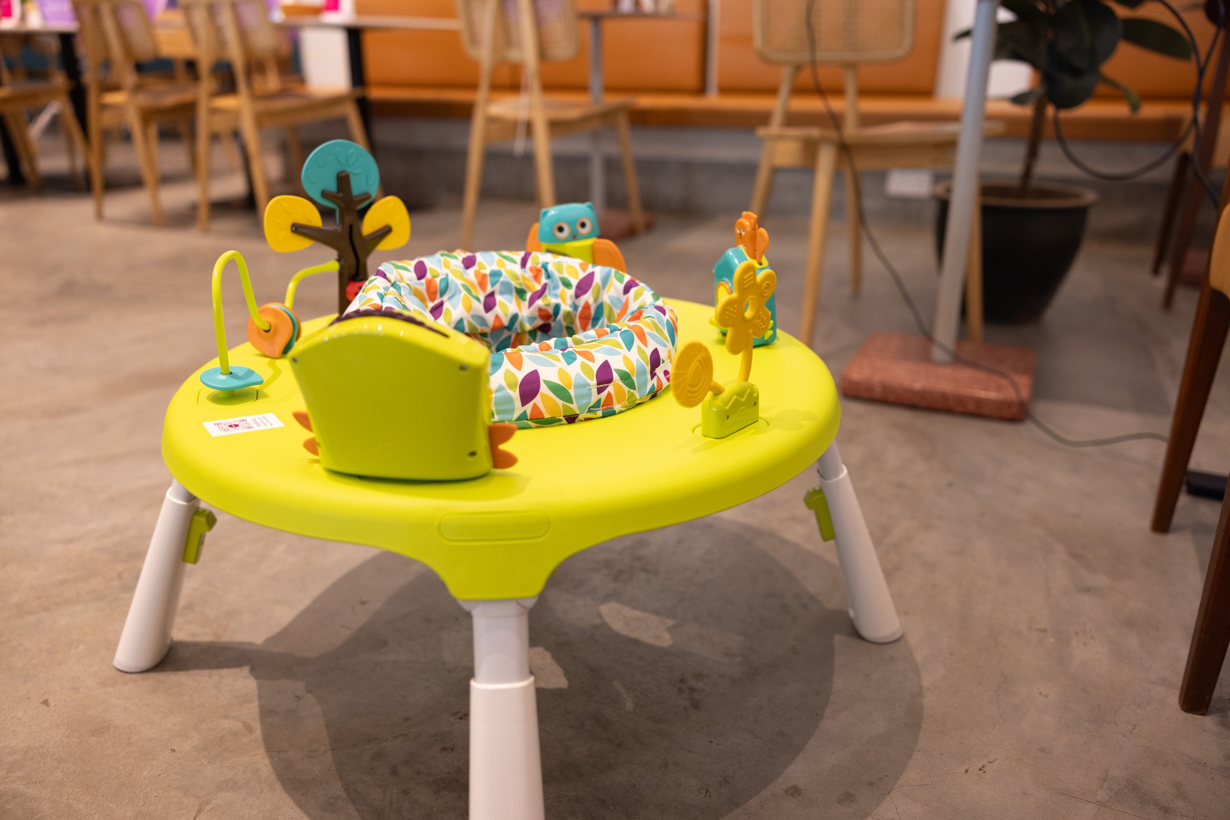  Close-up photograph of an Oribel interactive baby activity center table with developmental toys. 