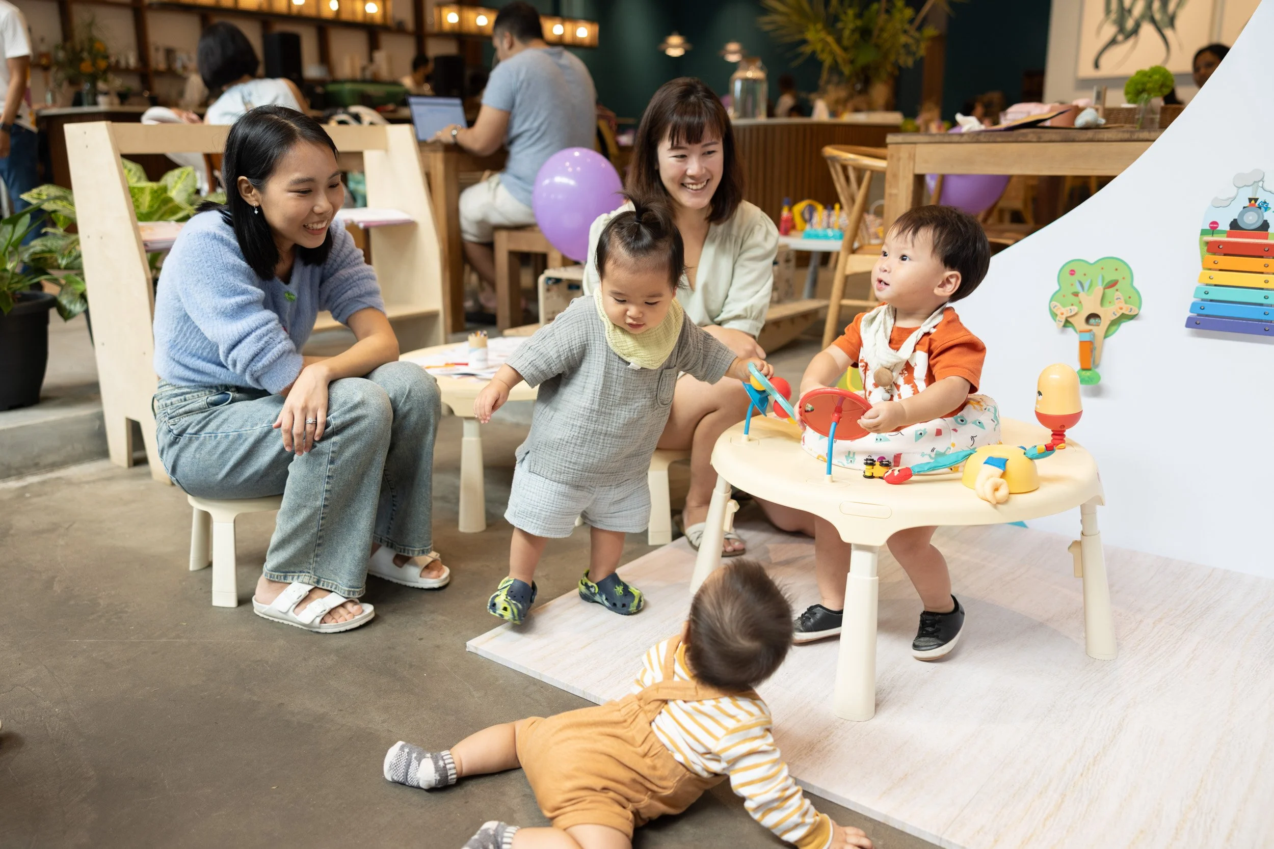  Mothers interacting with Oribel activity centers alongside their children. 