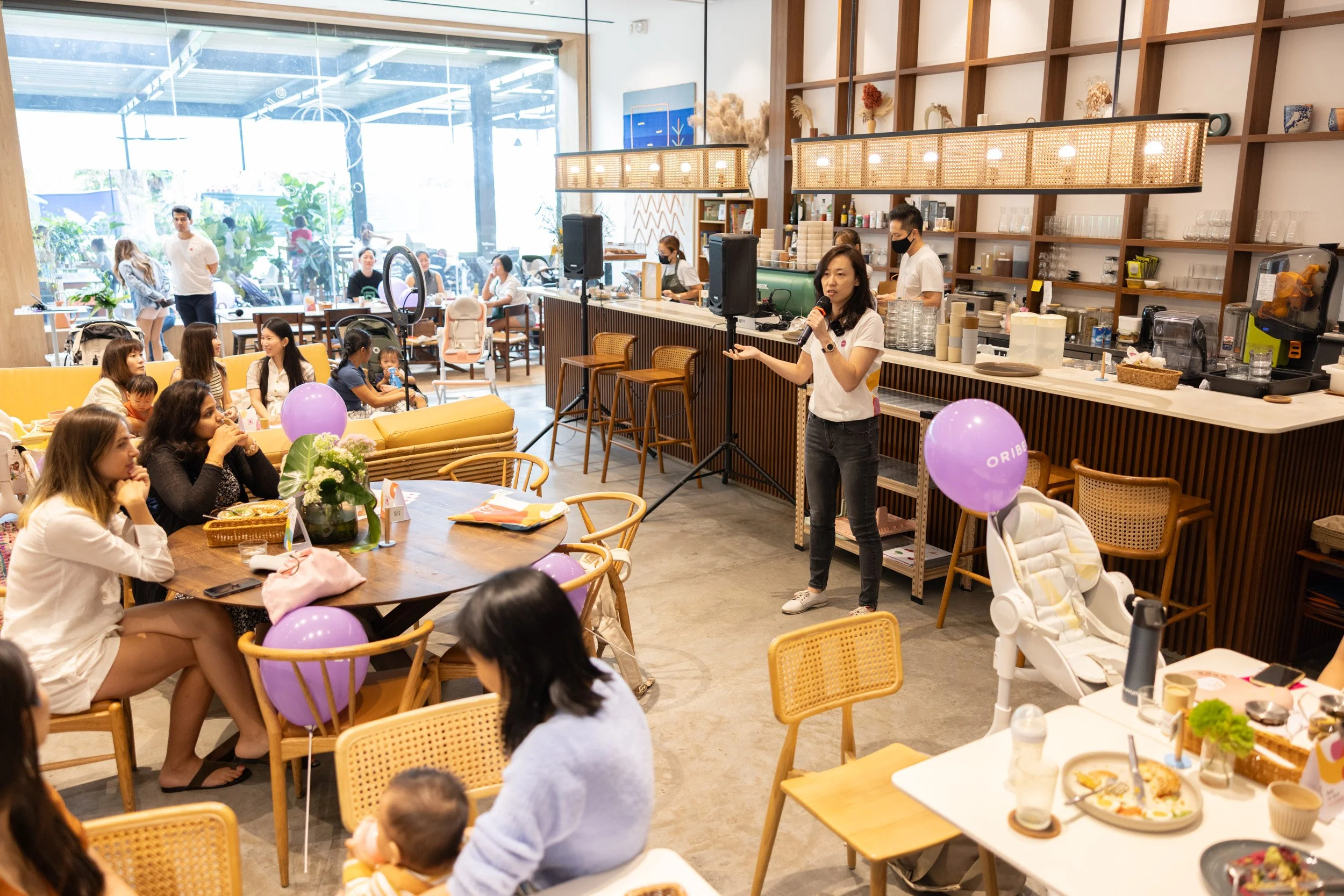  Wide perspective of founder Cindy Goh presenting parenting insights to attendees. 