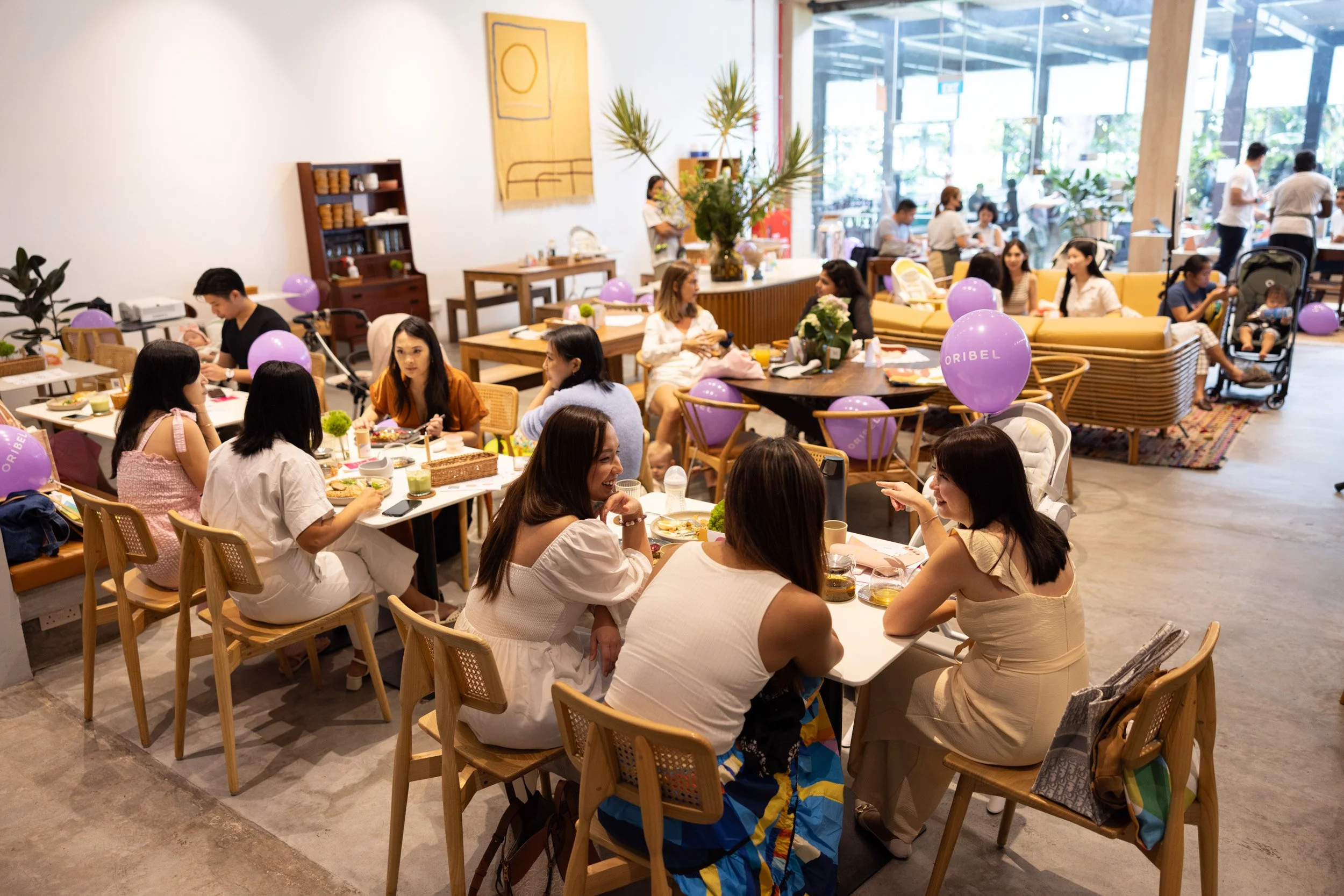  Seated crowd of mothers and influencers listening to the panel discussion at East Coast Commune. 