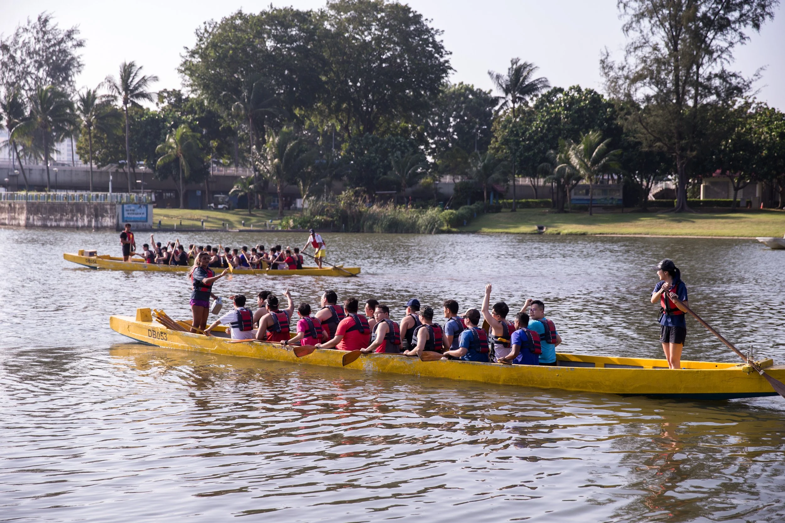  Medium shot of two dragon boats departing the Kallang Water Sports Centre launching pontoon. 