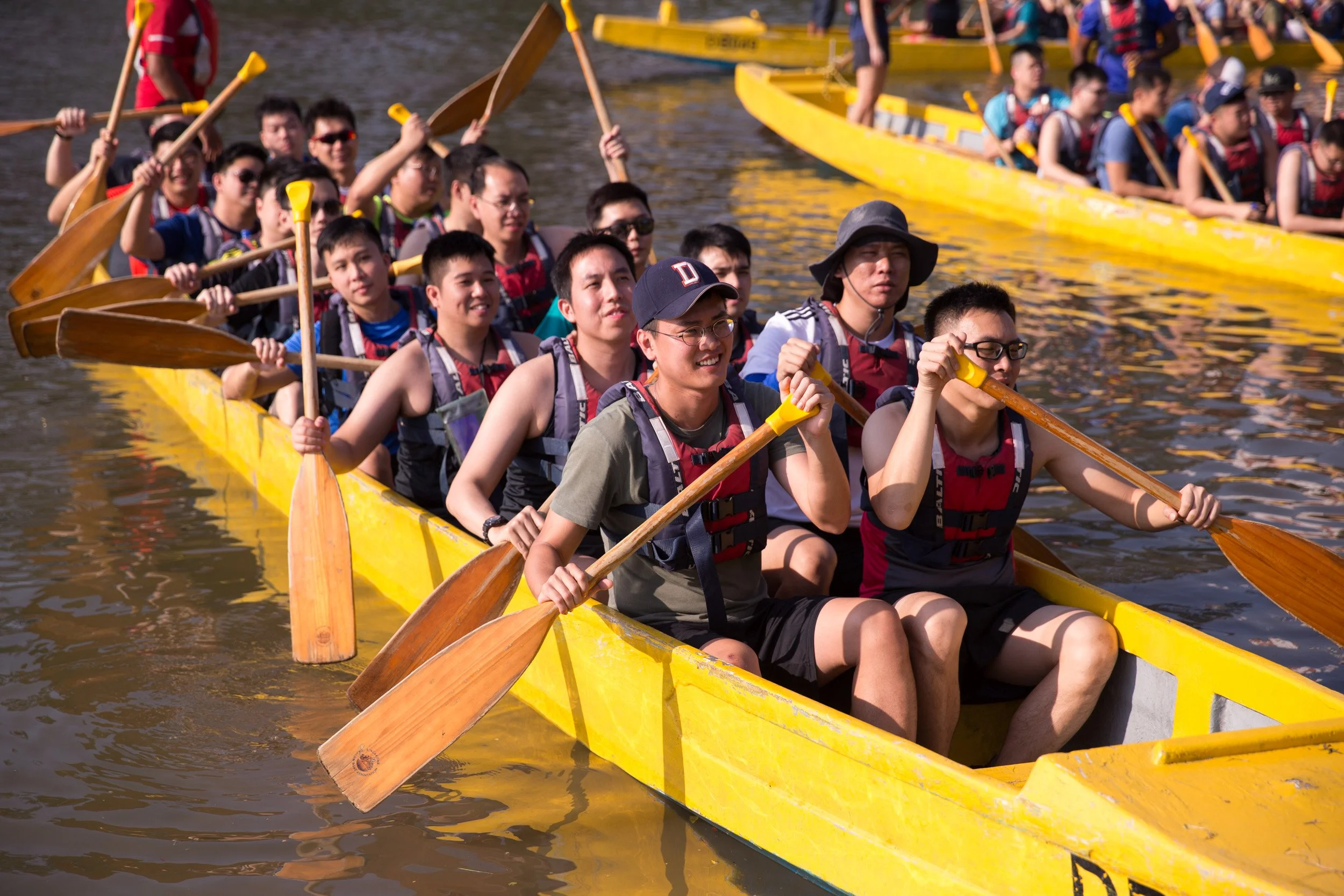  Action close-up of team members executing synchronized paddle strokes to propel their dragon boat. 