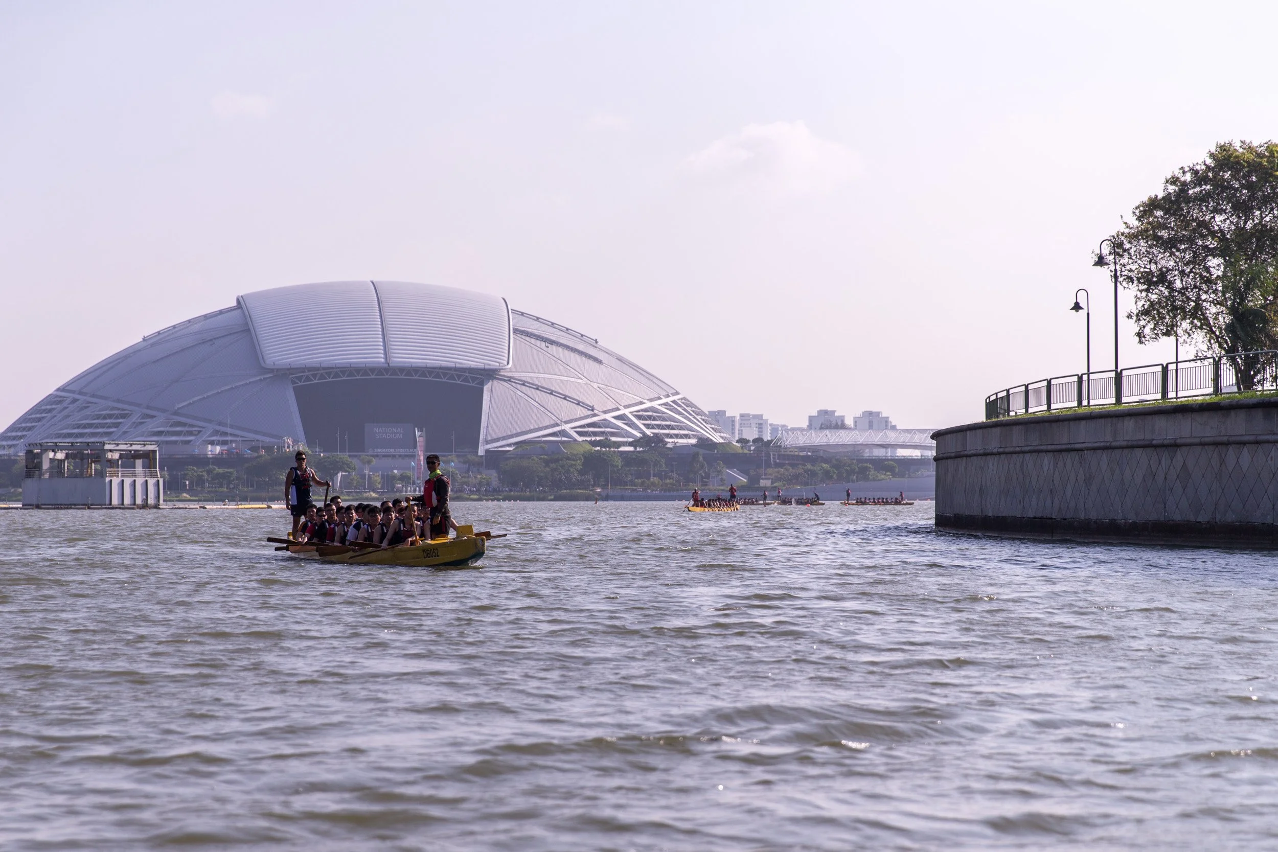  Silhouette shot of a dragon boat team paddling in front of the National Stadium dome at Singapore Sports Hub. 