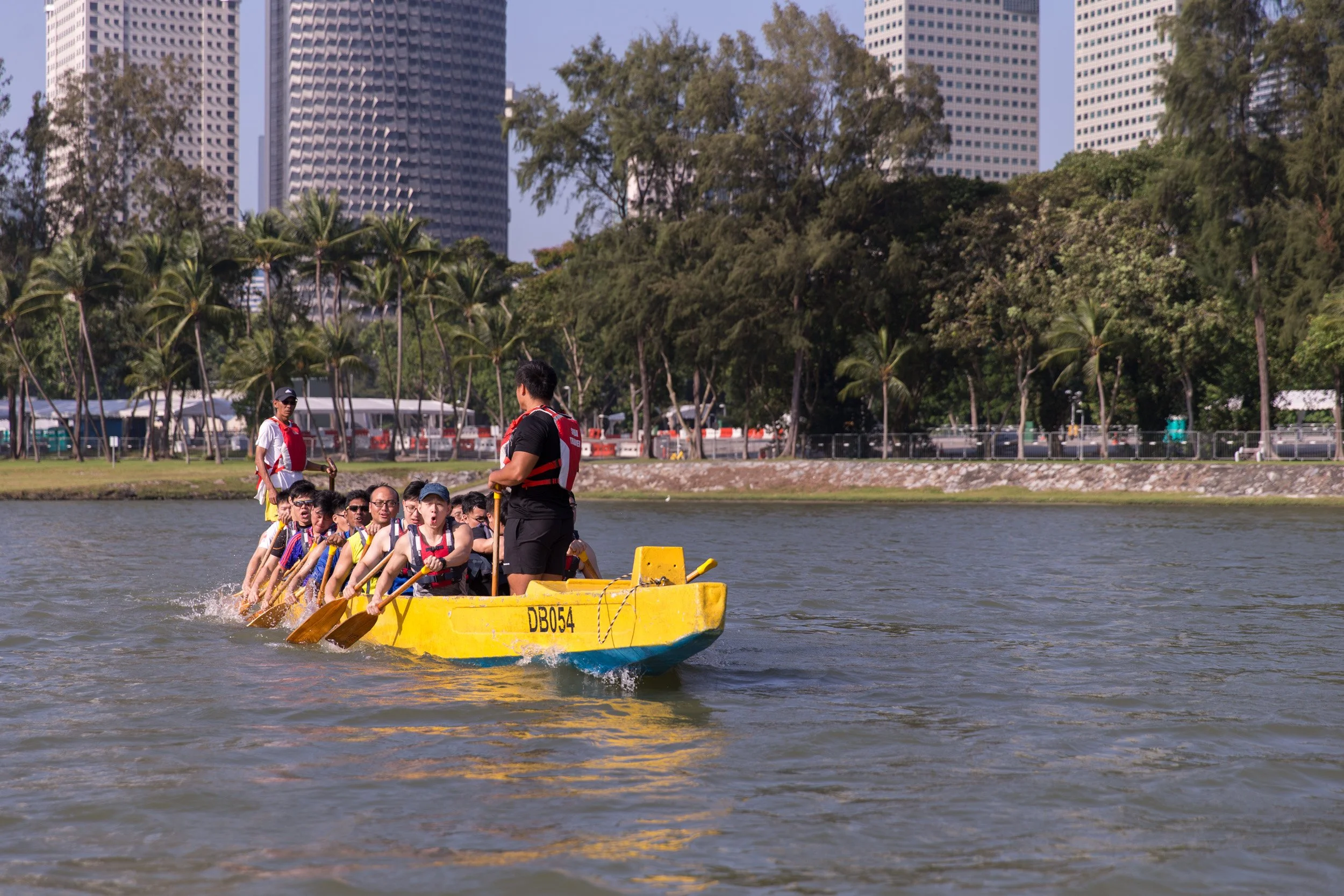  Front-facing medium shot of a Singapore Artillery dragon boat paddling toward the camera. 