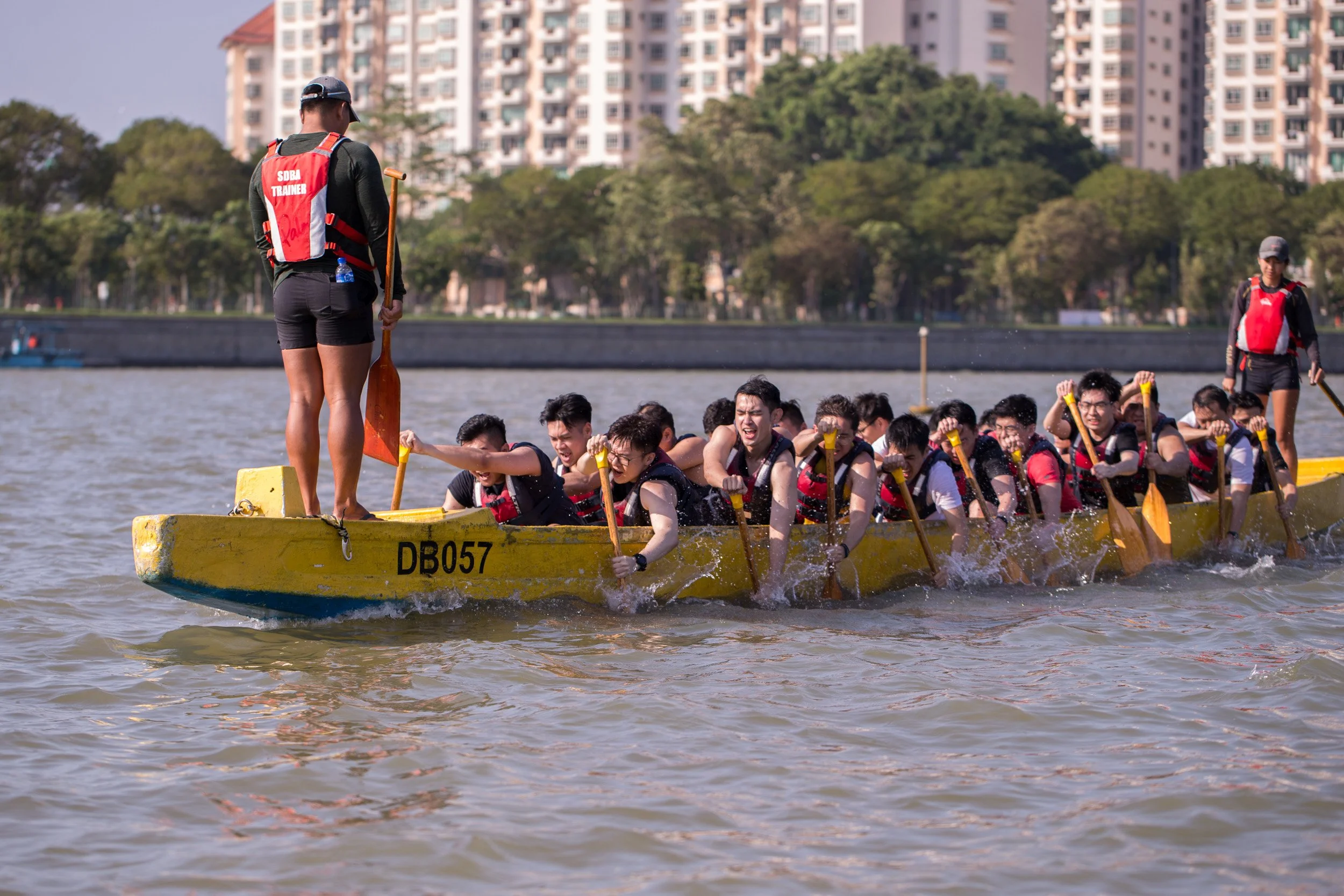  Mid-range action shot of rowers maintaining paddling rhythm on Kallang Basin. 