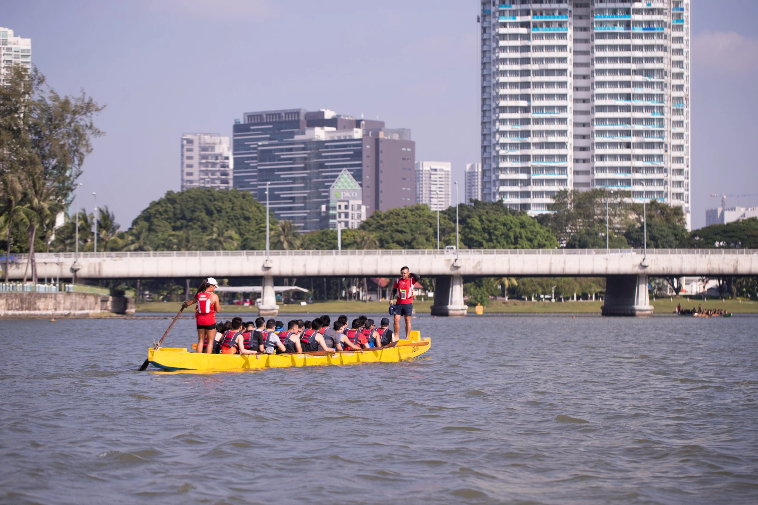  Wide view of a full dragon boat crew gliding across open water. 