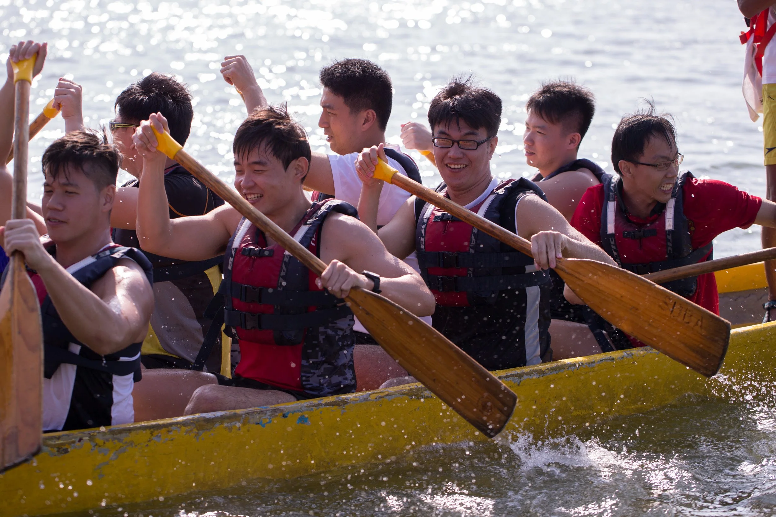  Tight action detail shot of team members driving paddles into the water. 