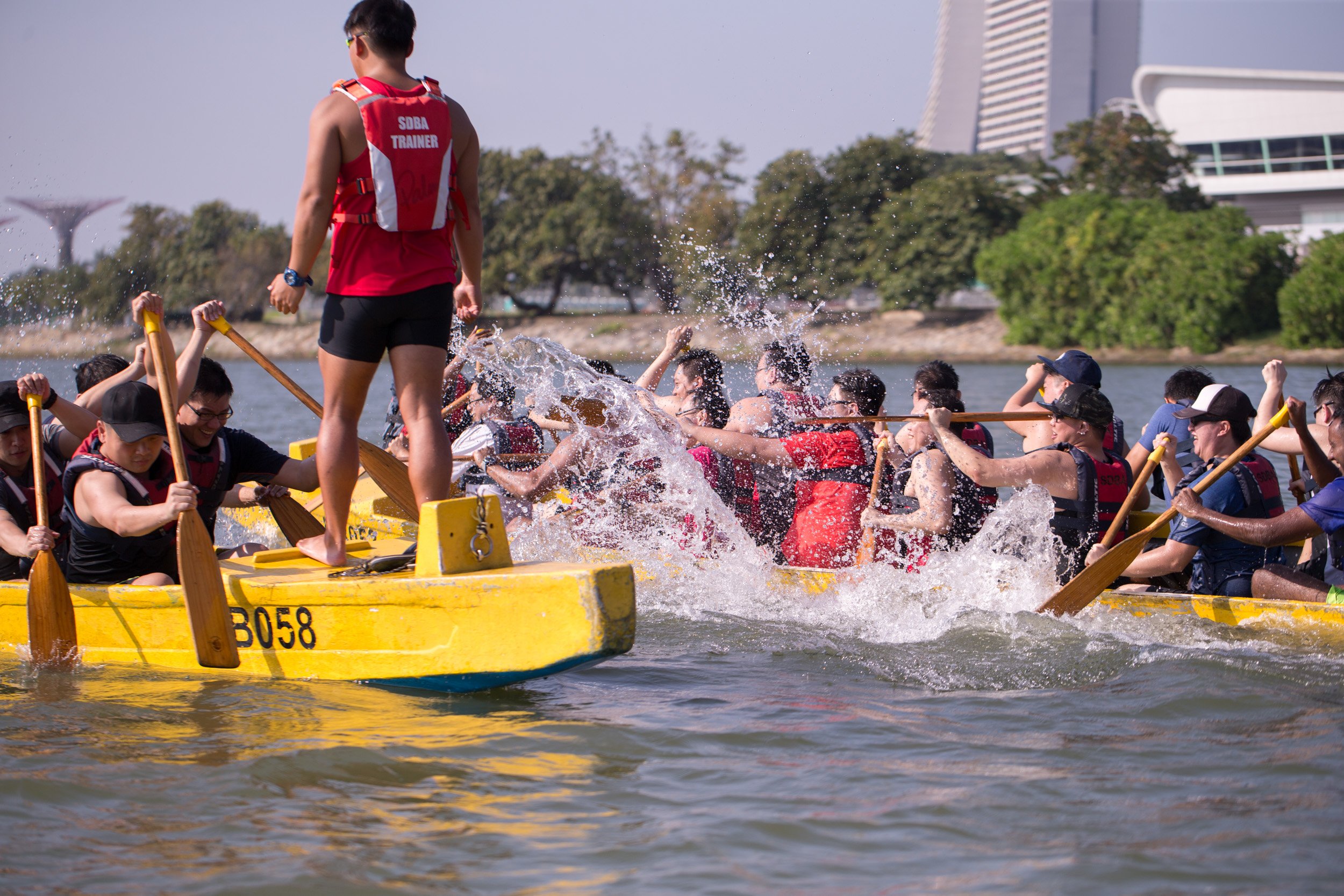  Dynamic close-up of two dragon boats side-by-side during a playful water-splashing match between participants. 