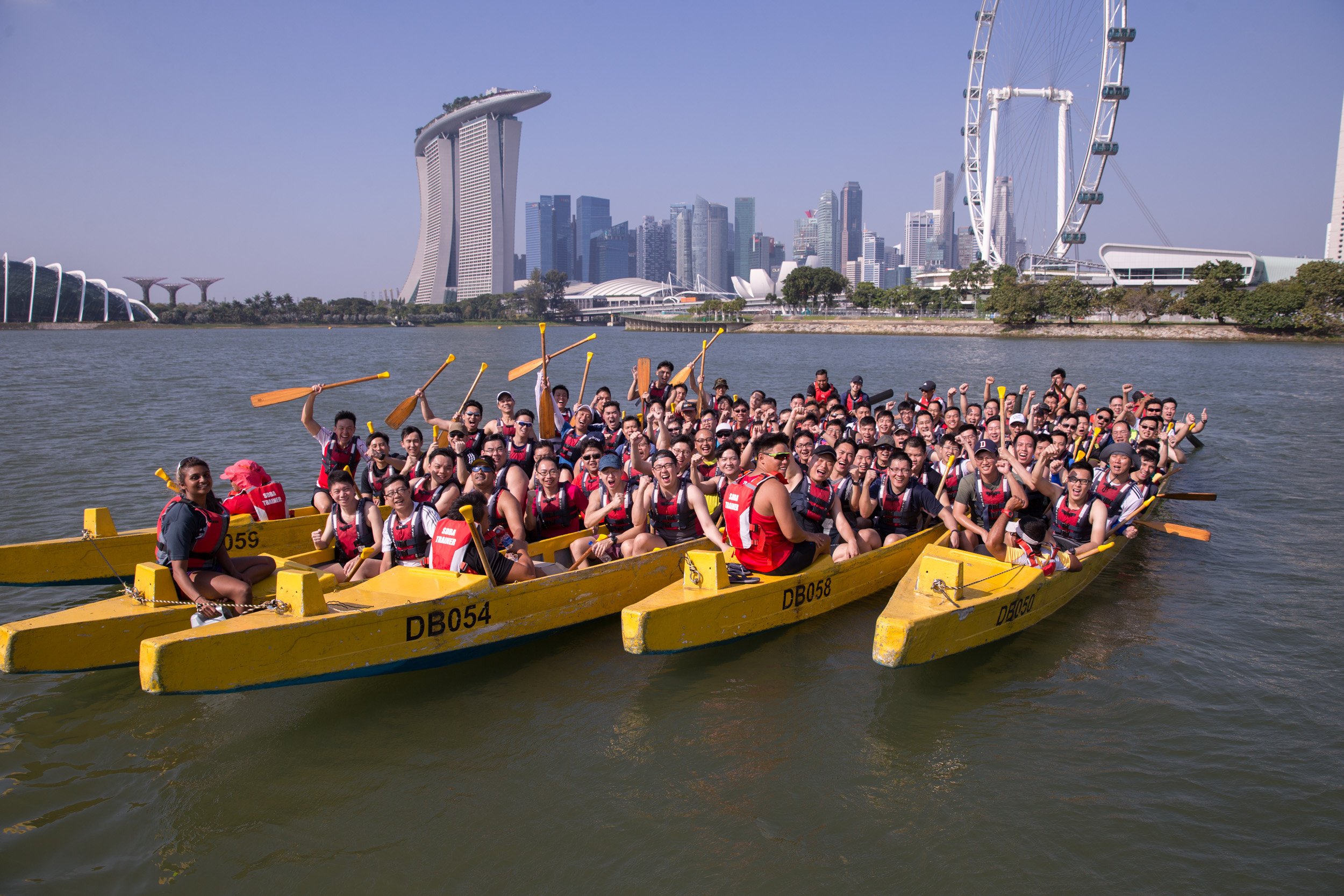 Final group photo featuring five dragon boats positioned together on Kallang Basin with all participants celebrating. 