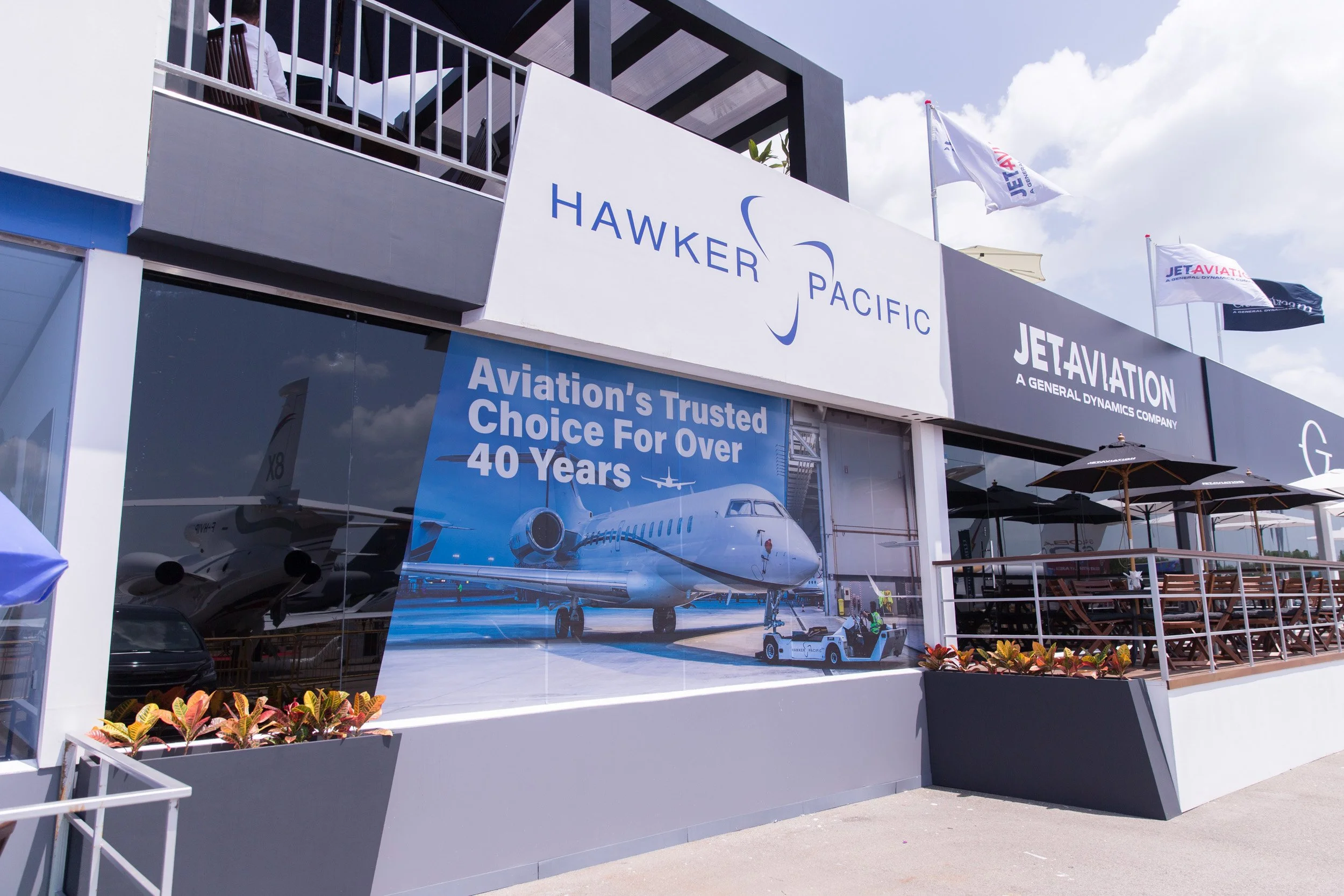  Rear facade of Hawker Pacific Hospitality Chalet displaying branded window poster featuring Tail Feather photography. 