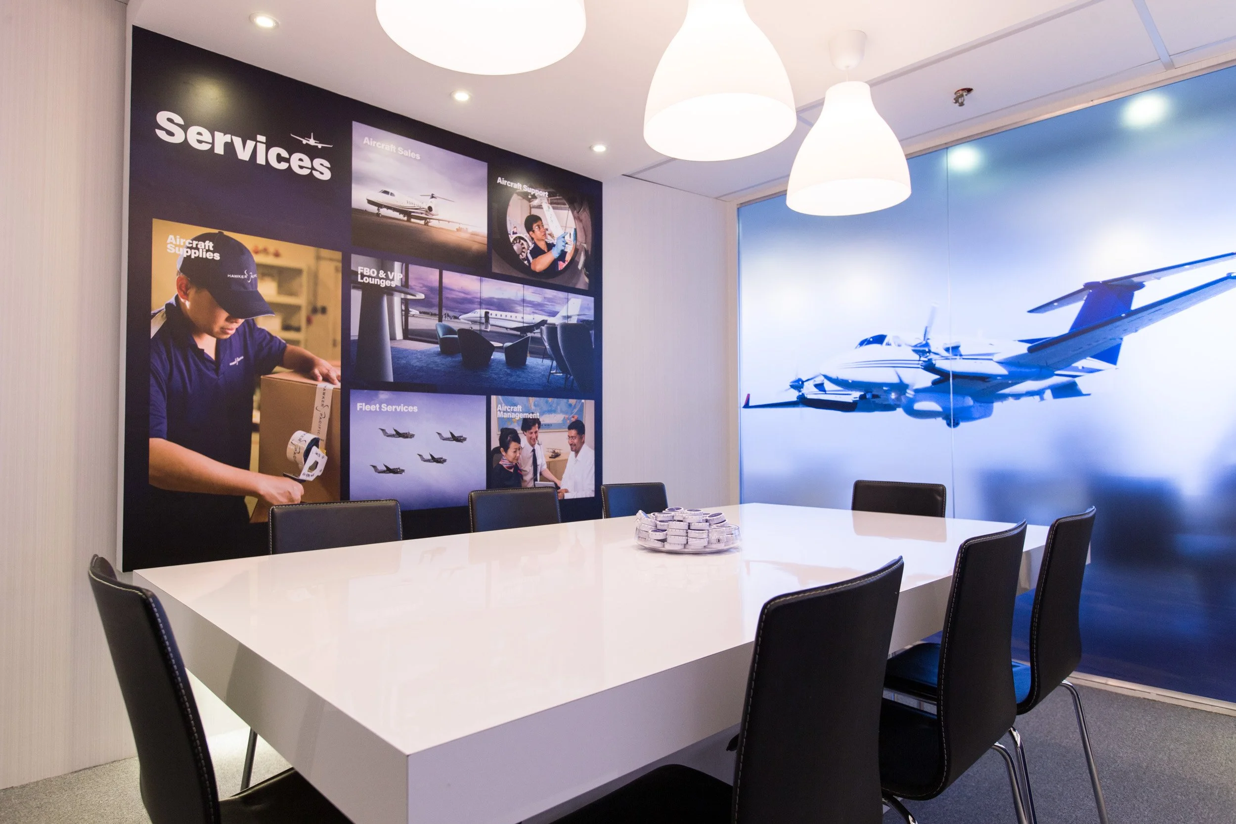  VIP meeting suite interior displaying aviation services poster with commercial photography by Tail Feather. 