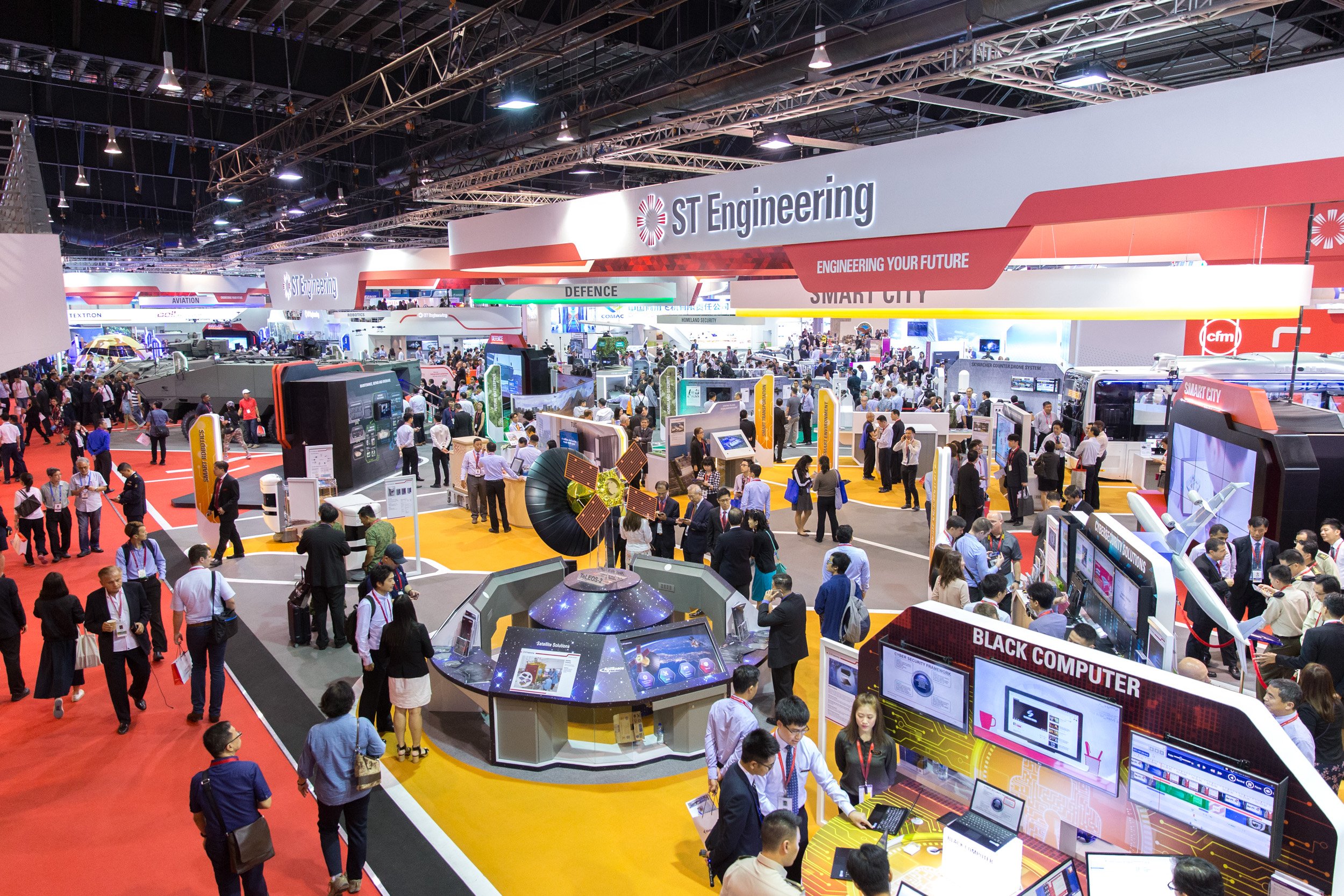  Wide upper-level view showcasing major defense contractor pavilions and aviation displays. 