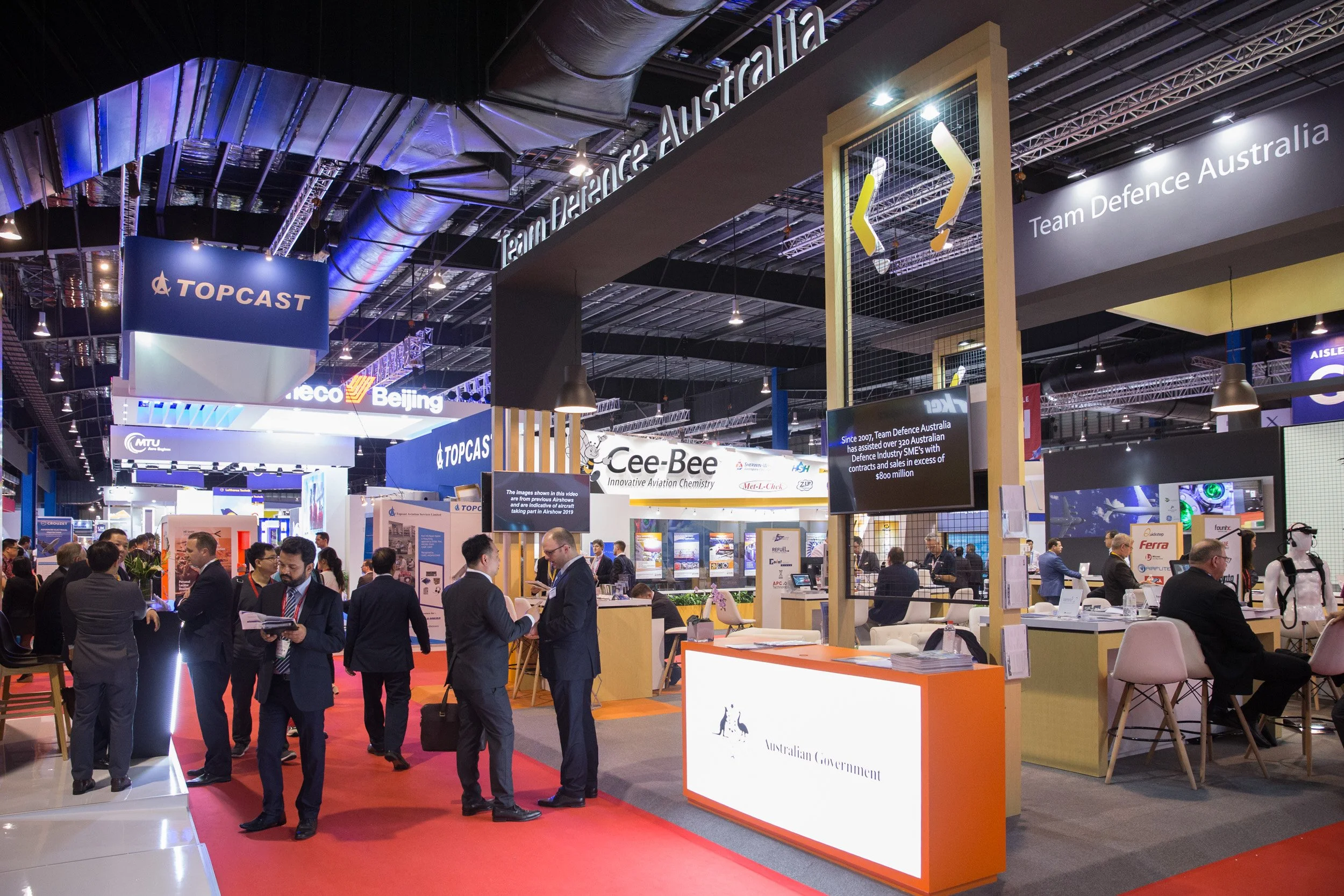  Trade visitors passing the Team Defence Australia pavilion inside the Singapore Airshow exhibition hall. 