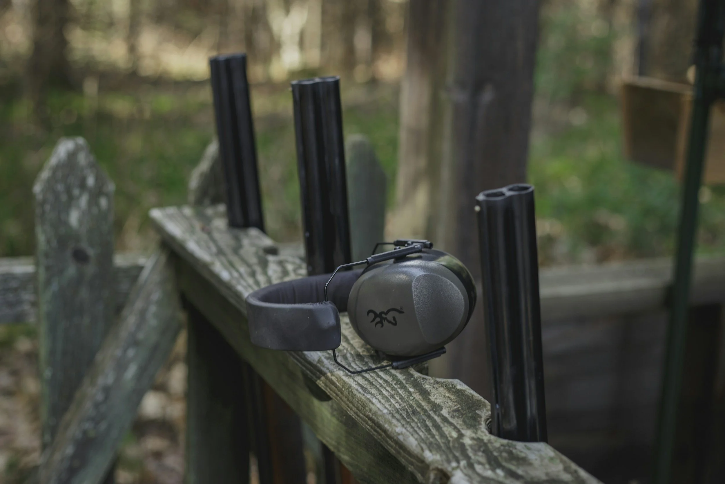 Shotguns on a rustic rack in the woods. click to learn about the shotgun club