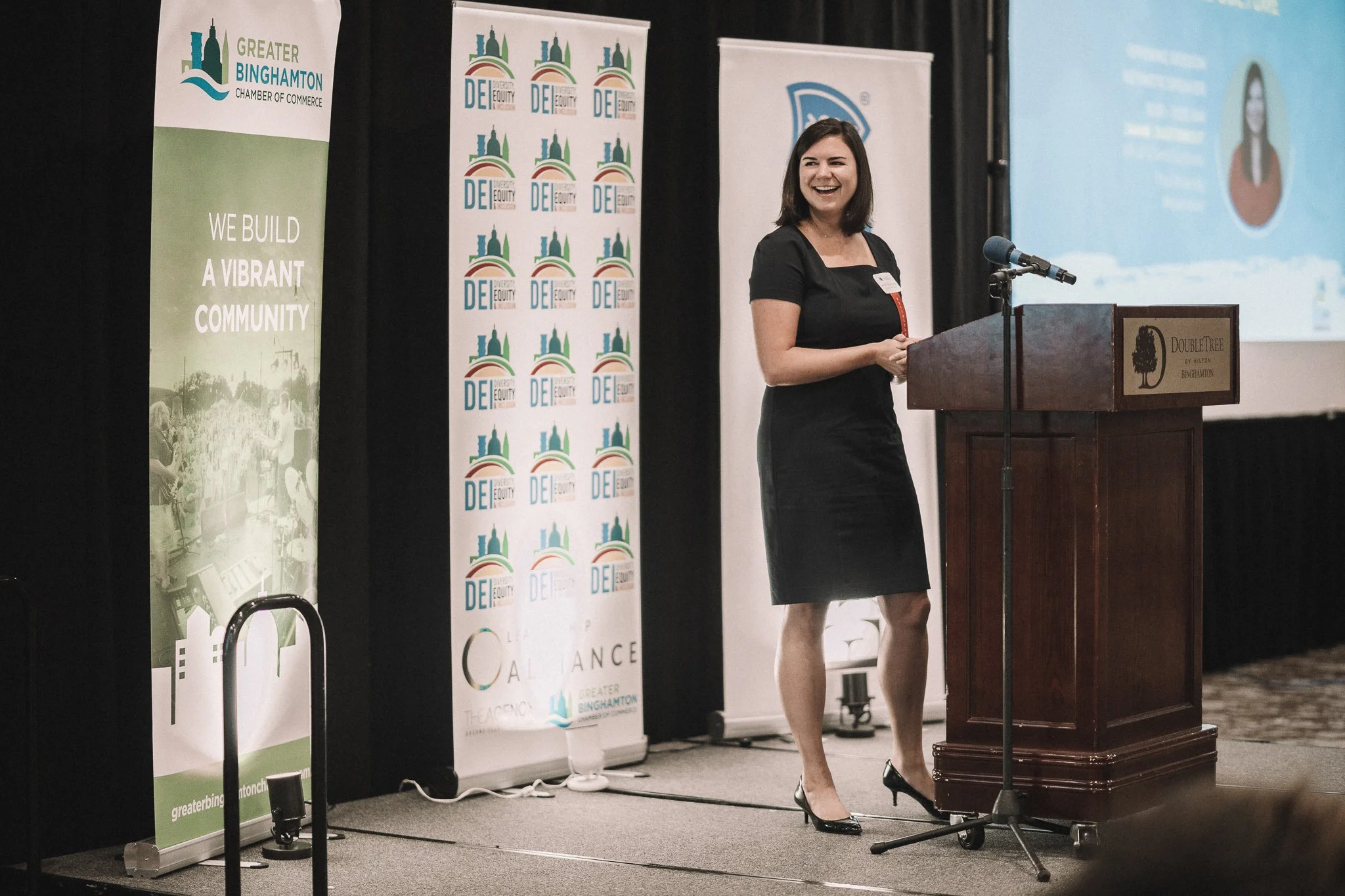 Picture of Jamie Ousterout presenting onstage at a keynote, smiling.