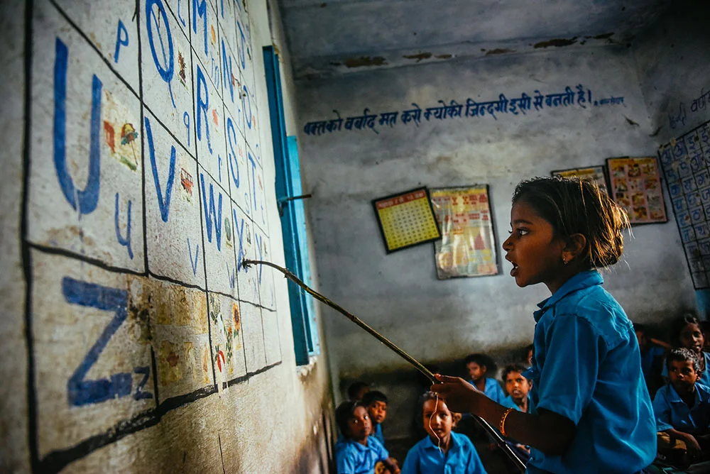 A young girl practices the english alphabet in front of her class during school in Rajasthan, India. Educate Girls, a local nonprofit, focuses on encouraging young girls to attend school in order to improve their opportunities in life. Photo © James Roh.