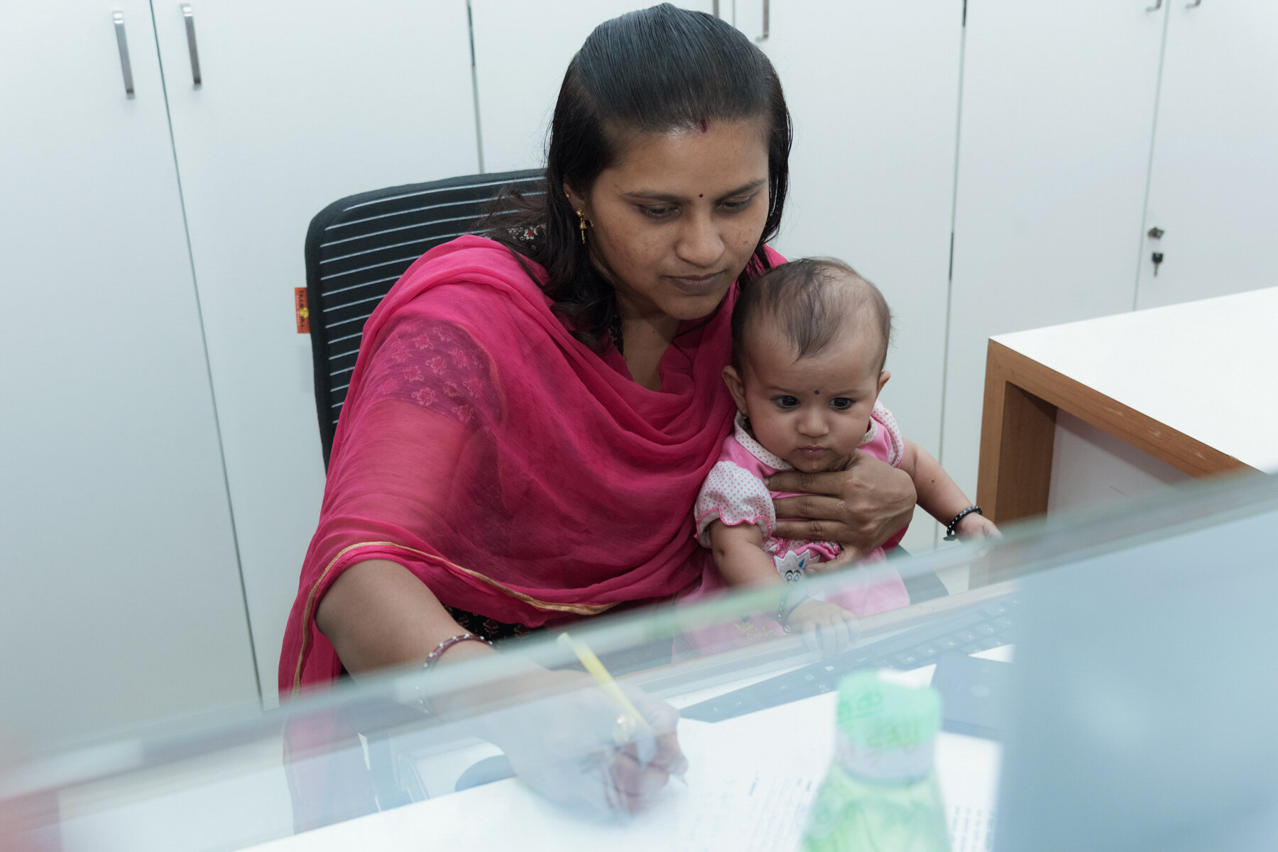  Mann Deshi Bank employee Kirti Pawar at work with her 4-month-old son. The bank gives job preference to local women, who are encouraged to bring their children to work. 