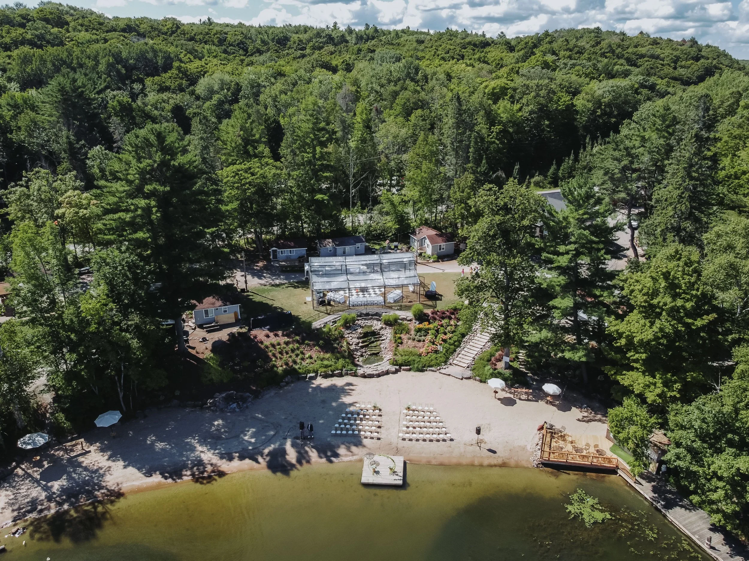 Drone photograph of Forest Rock Resort in Muskoka, a lakeside wedding venue with cabins and beach, captured by Maple & Clover.