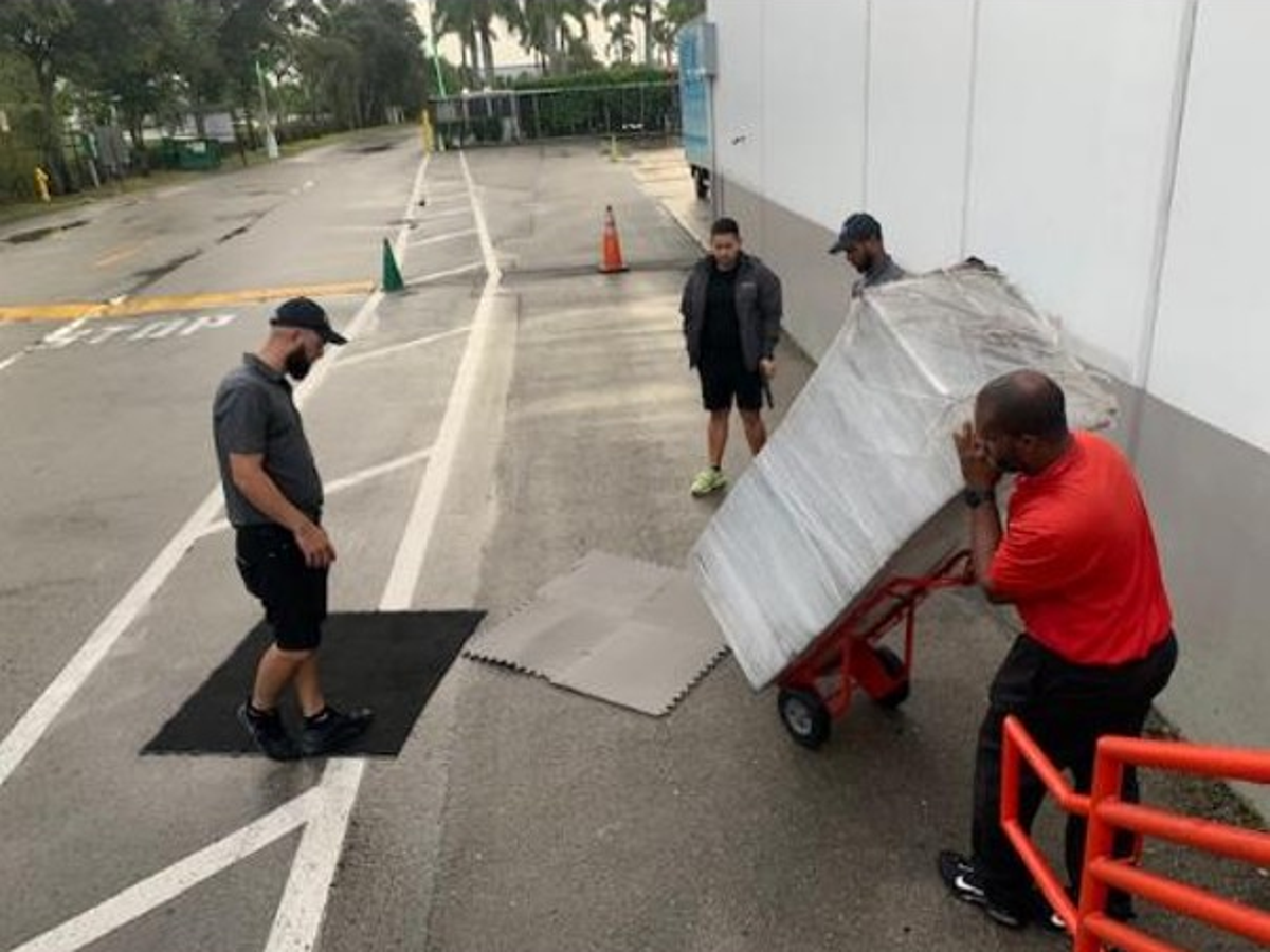 Manufacturing team testing a safer material handling process during a Kaizen event led by Adam Lawrence, improving safety, workflow, and operational performance.