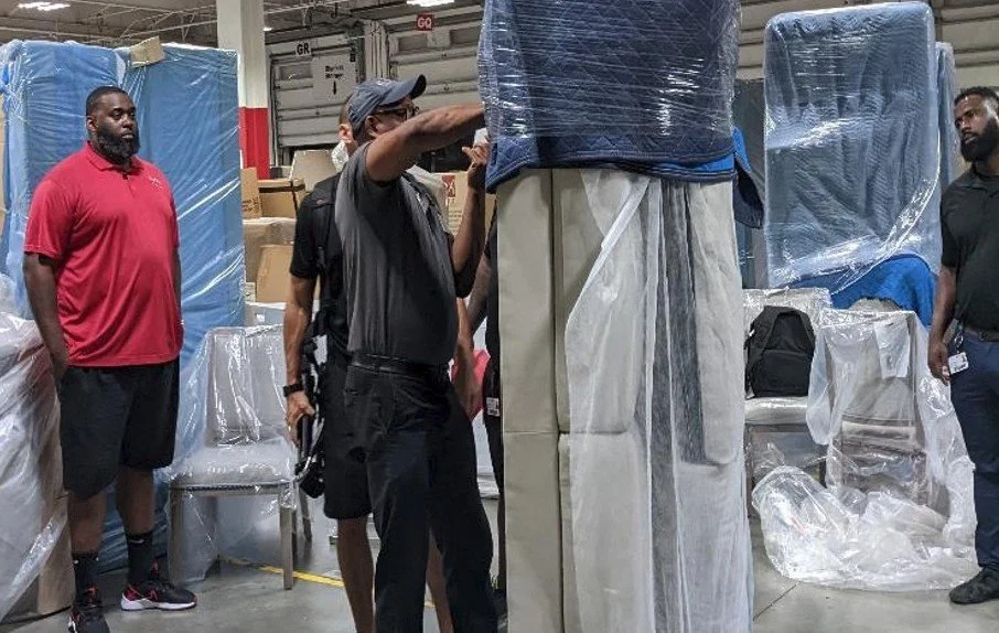 Manufacturing employees participating in a Kaizen event, observing and evaluating workplace layout improvements to reduce waste, improve flow, and increase operational efficiency.