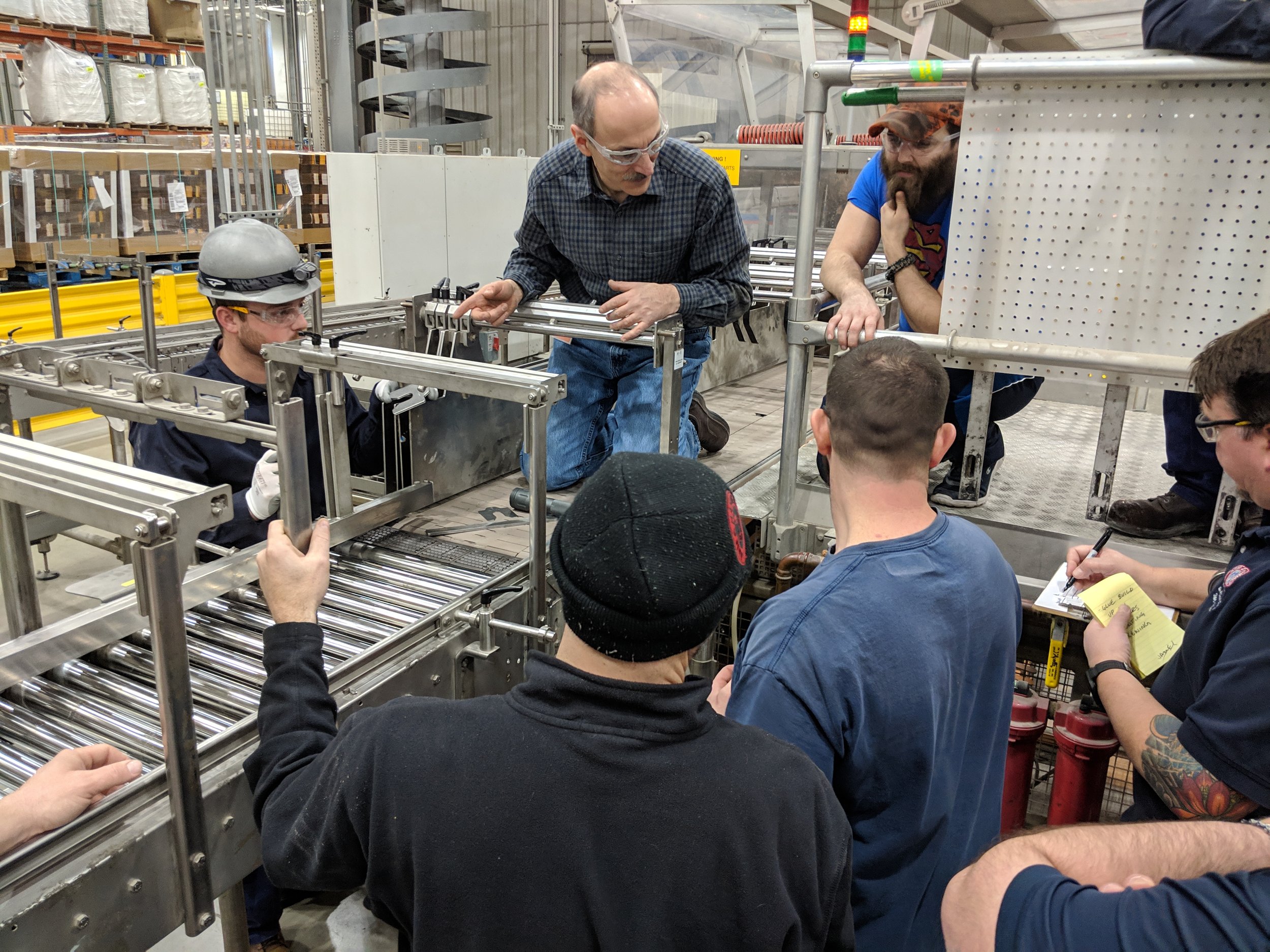 Adam Lawrence coaching a manufacturing team at the Gemba to identify opportunities, solve problems, and create sustainable improvement results.