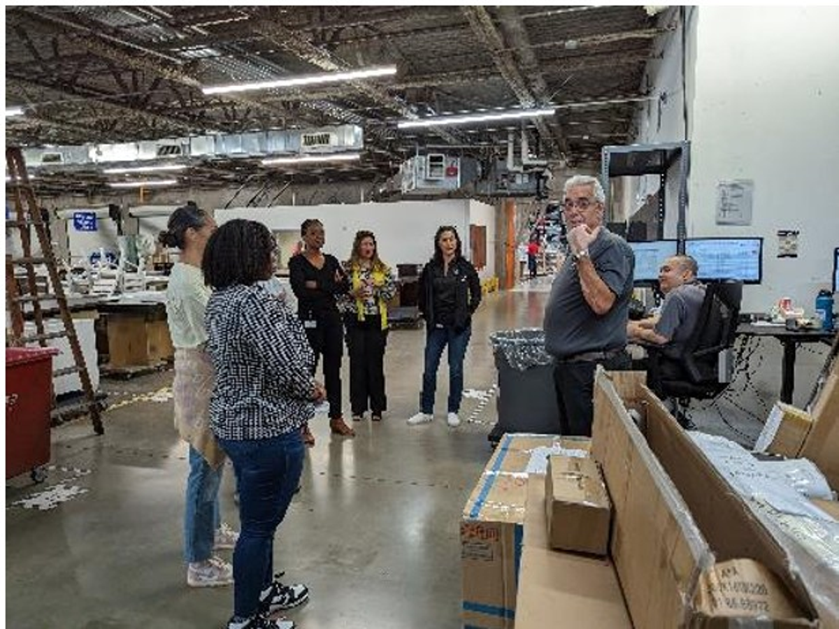 Adam Lawrence leading a manufacturing Gemba walk with leaders and team members, building leadership engagement, operational understanding, and continuous improvement.