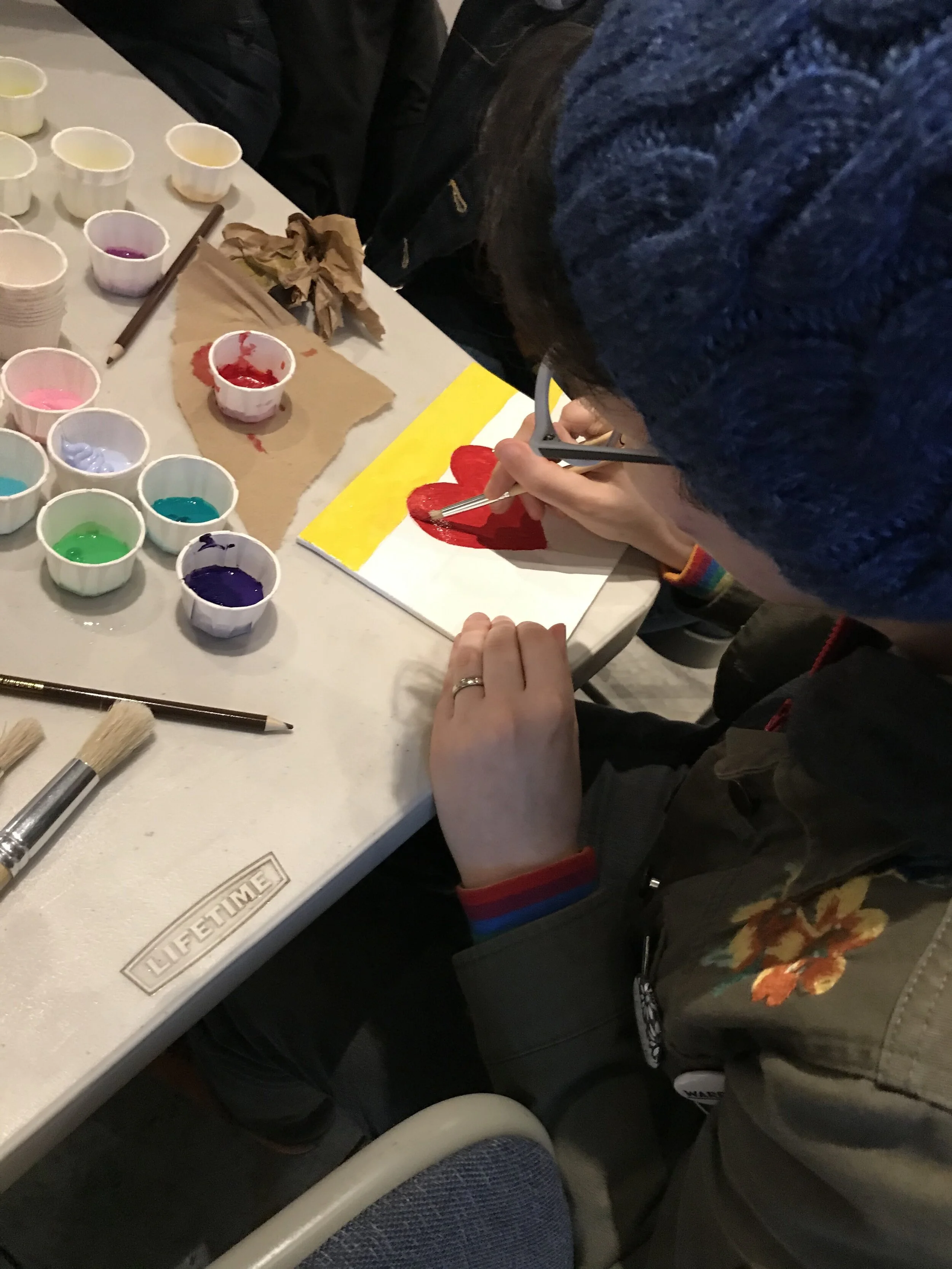 A participant at the January flag-making workshop creates a unique LGBTQ flag. Photo by Leigh Pfeffer.